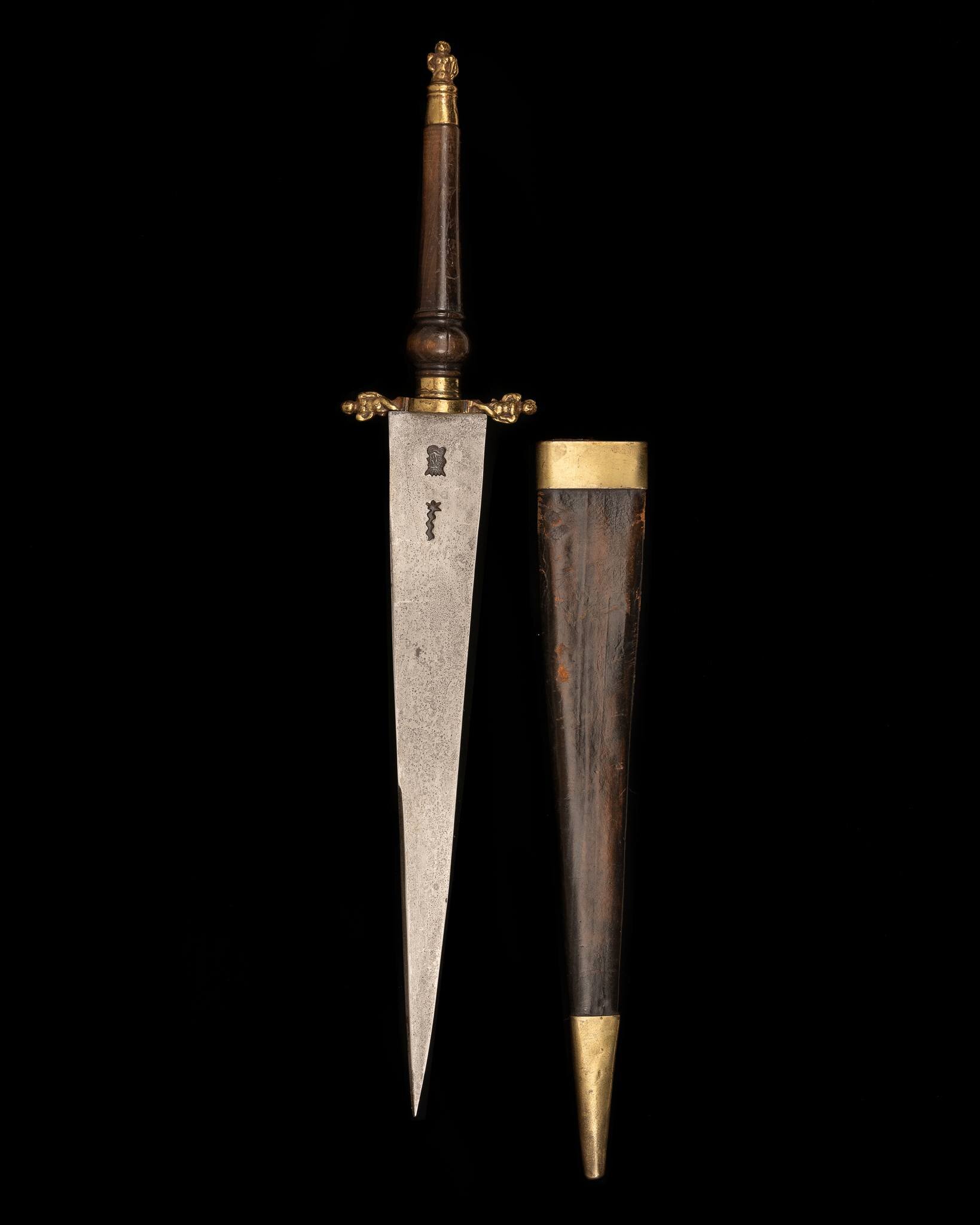 Large 17th Century Plug Bayonet

A 17th century British plug bayonet, originally out of the Hampton Court collection. Housed in its original scabbard  with a large well marked blade and winged figures, representing Erotes from Greek Mythology

The bl