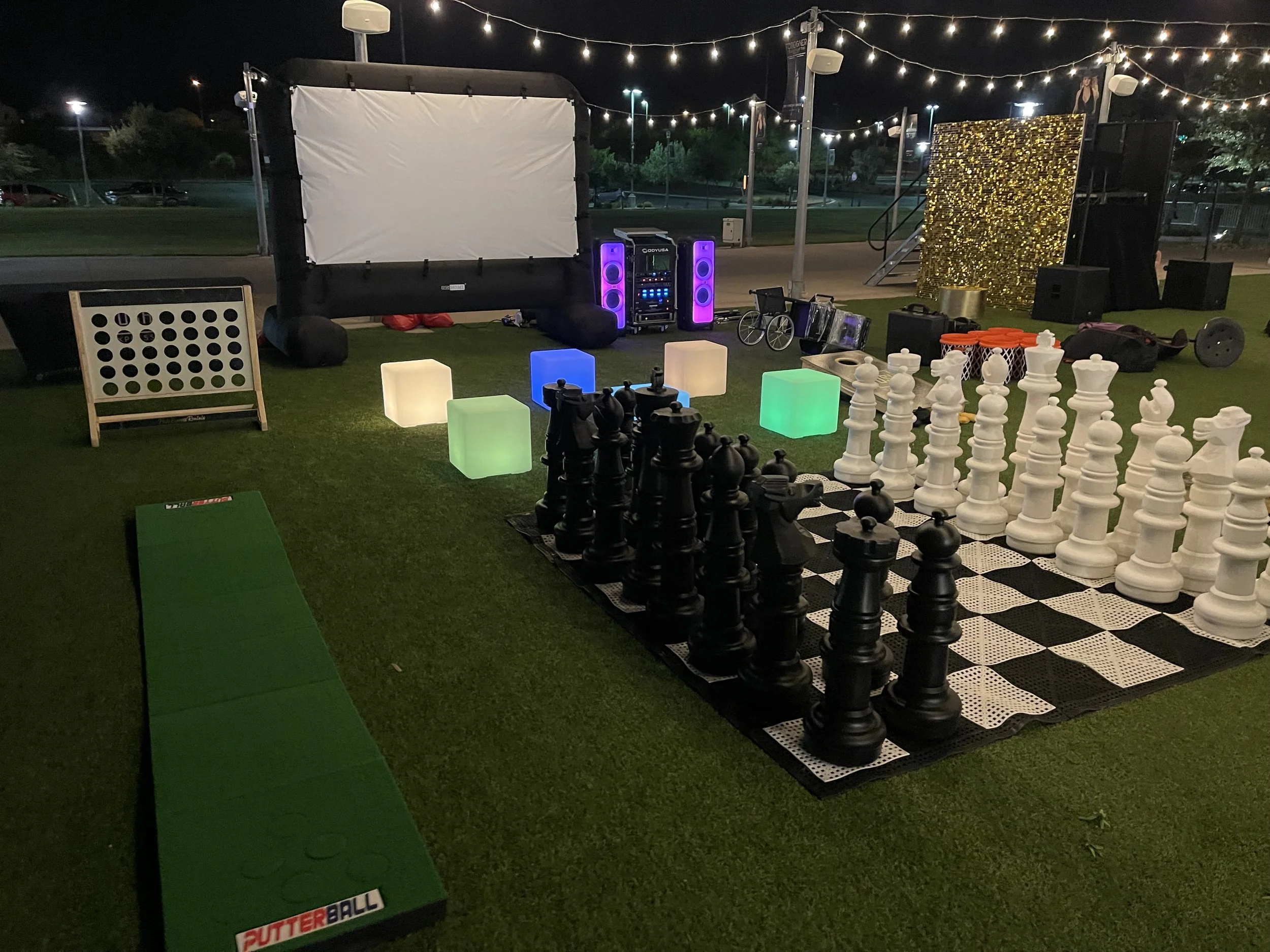 Outdoor setup with giant chess, Connect Four, and screen