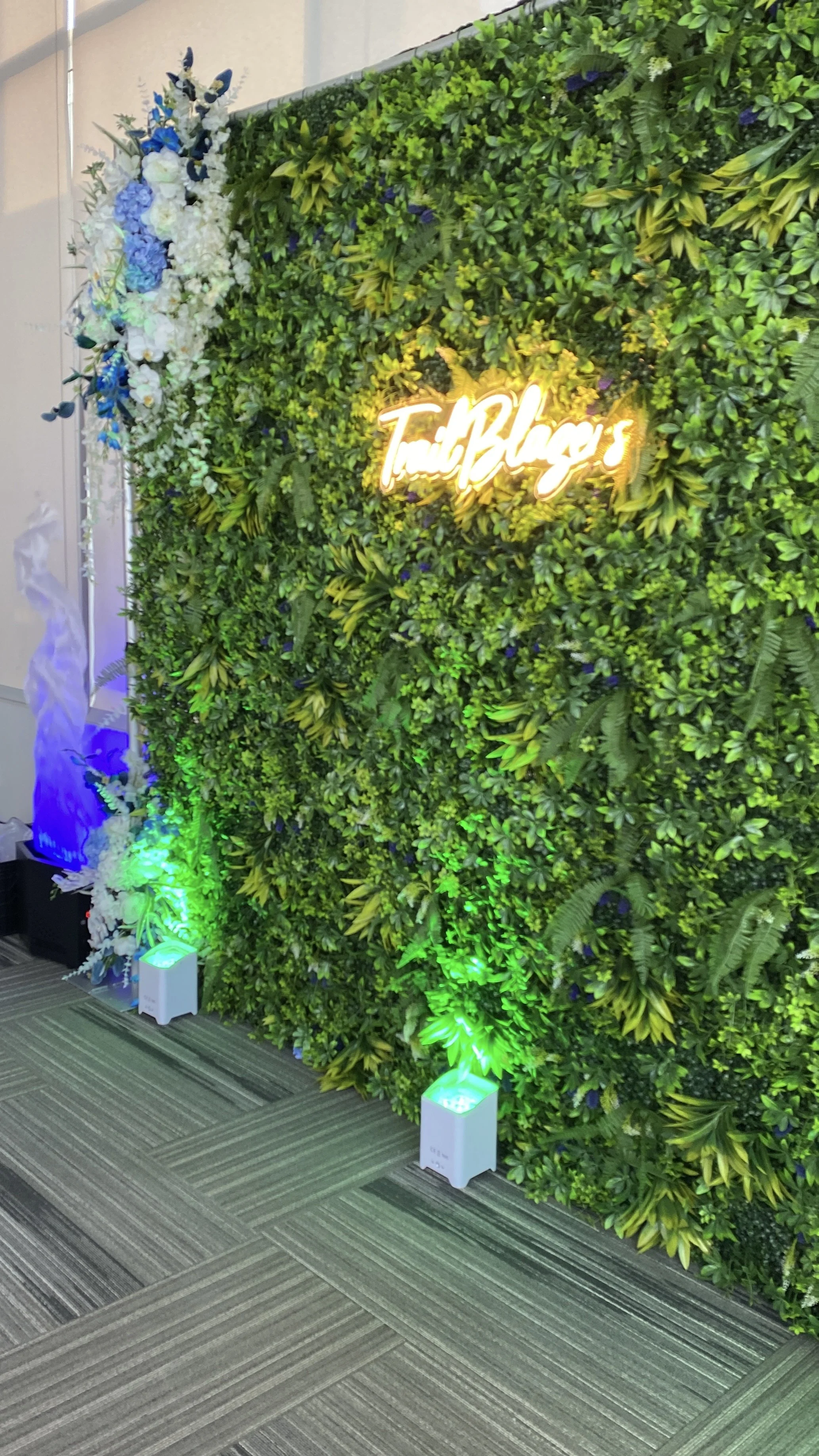Lush 3D greenery wall backdrop creating natural elegance for weddings and corporate functions, available through premium party rentals for sophisticated photo opportunities and event décor