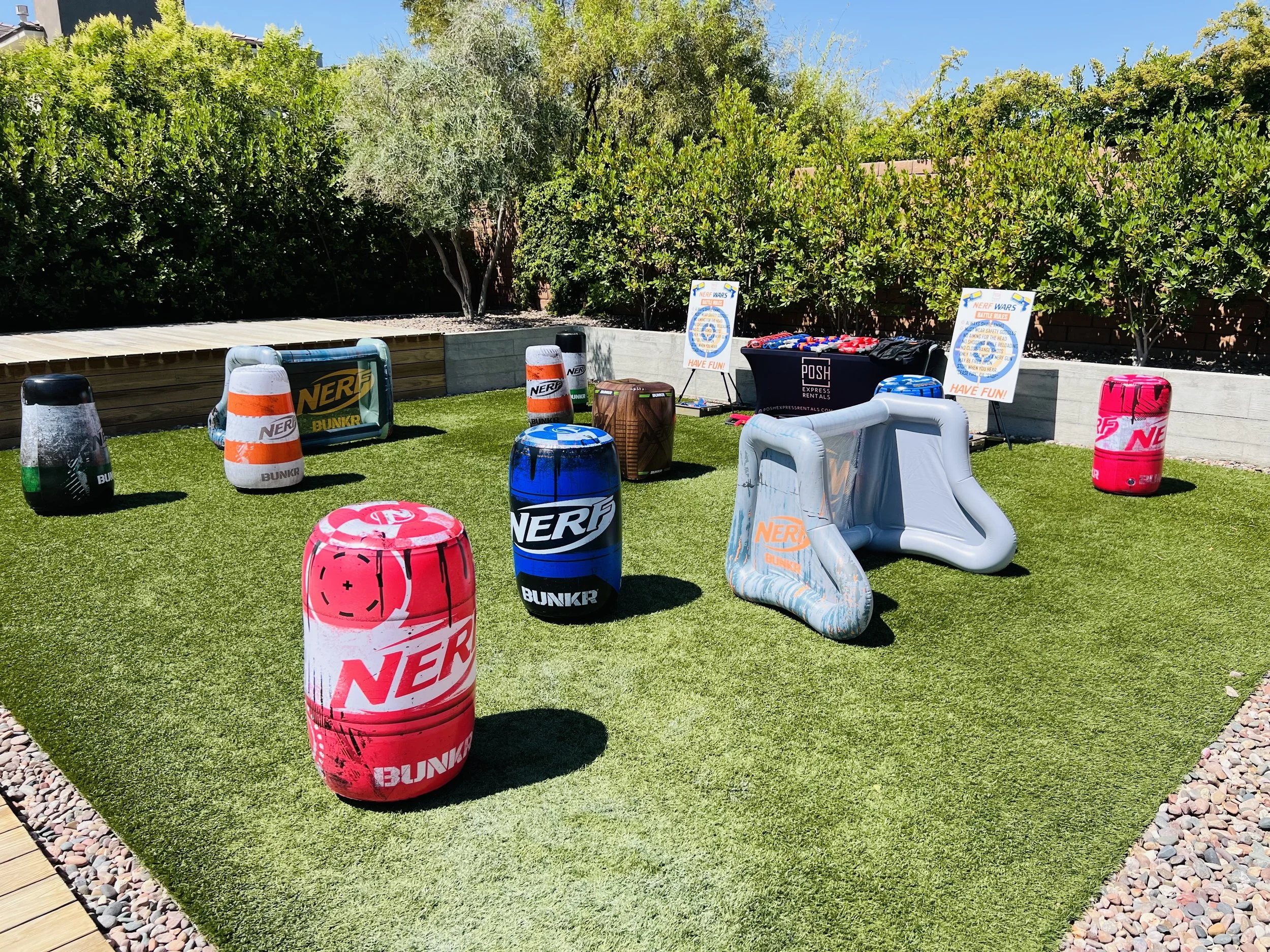 Outdoor NERF play area with inflatable bunkers on grass