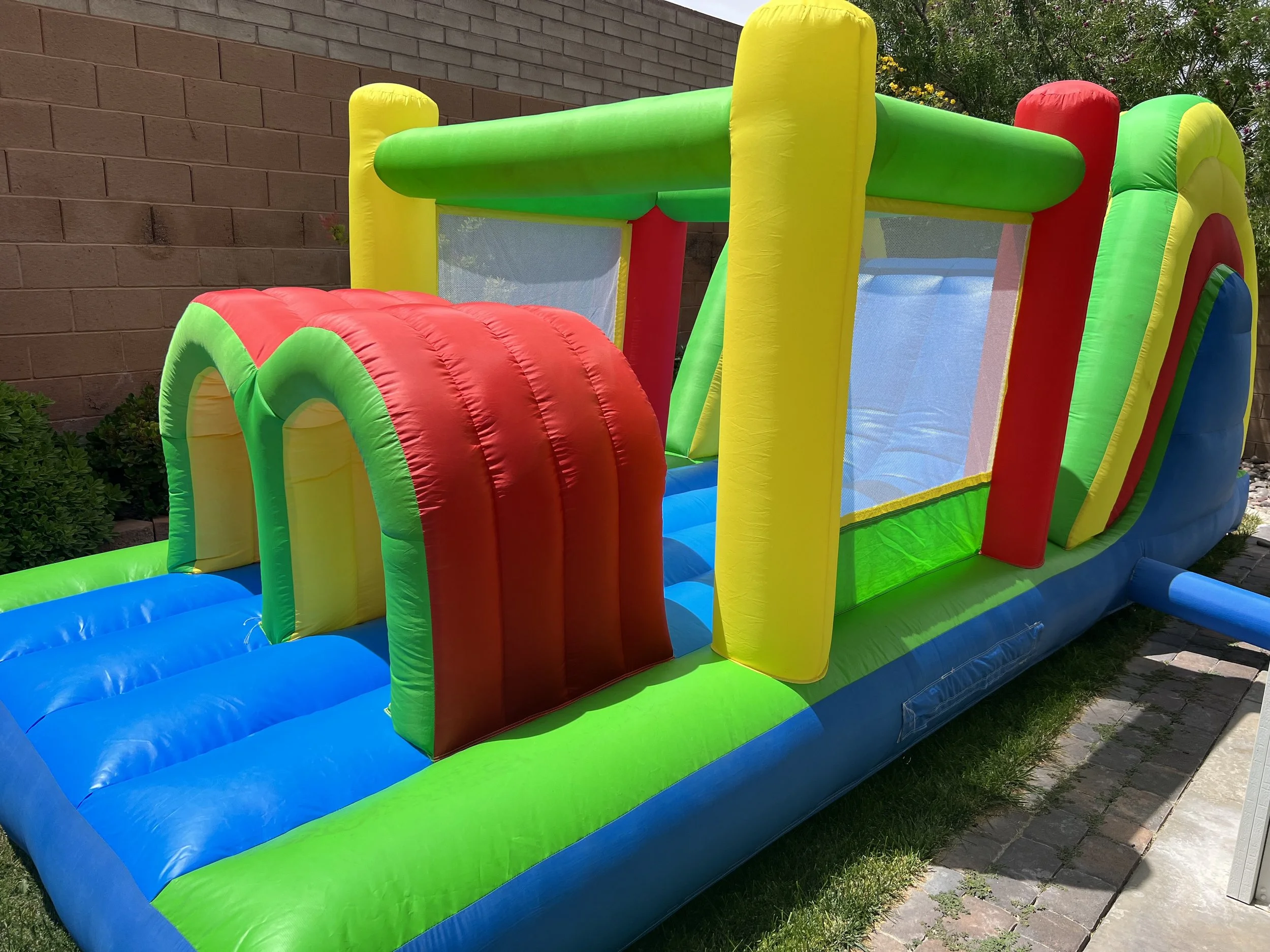 Colorful inflatable bounce house with slide in backyard.