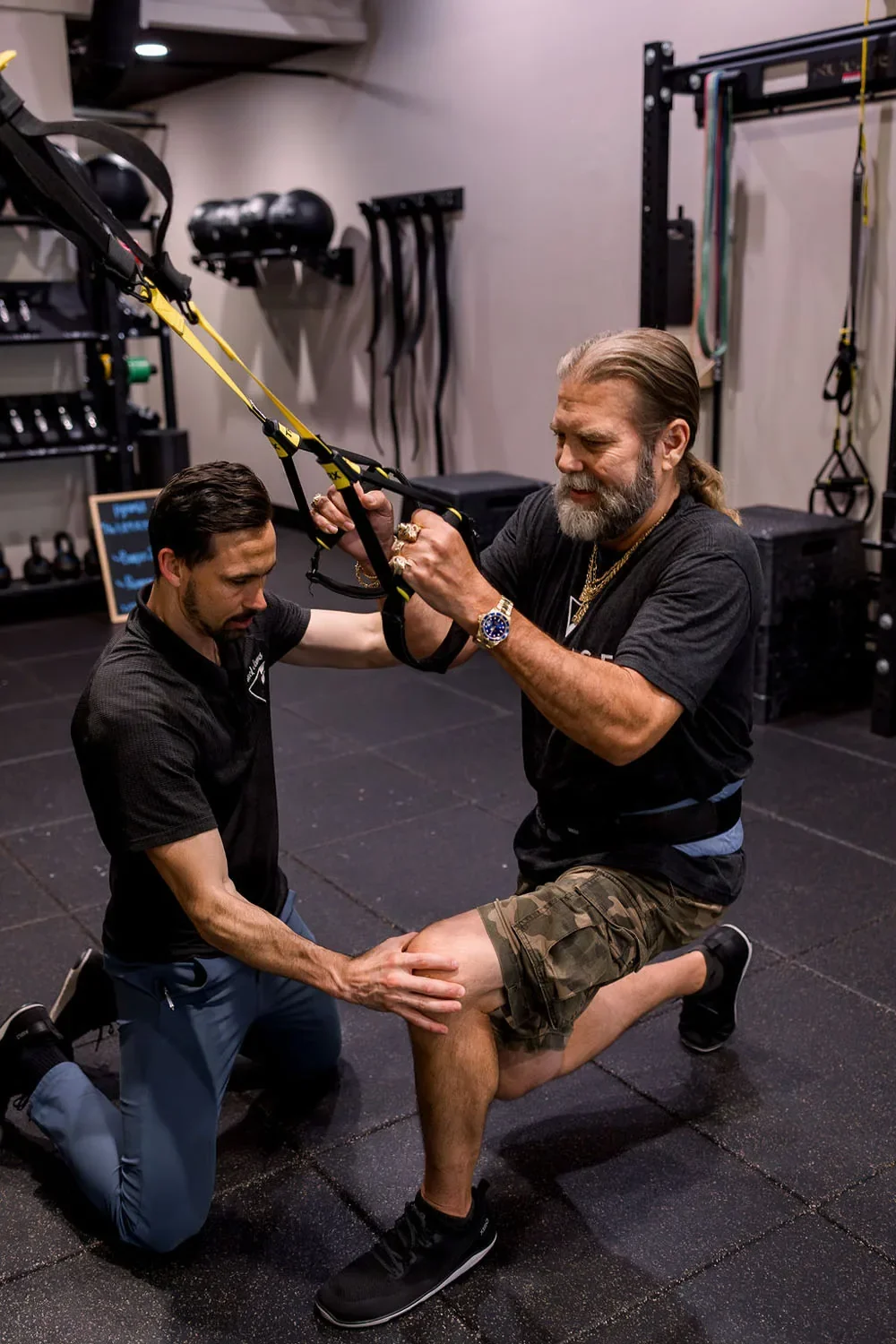Village Fitness personal trainer supporting a trx assisted lunge in one to one training session in glendora
