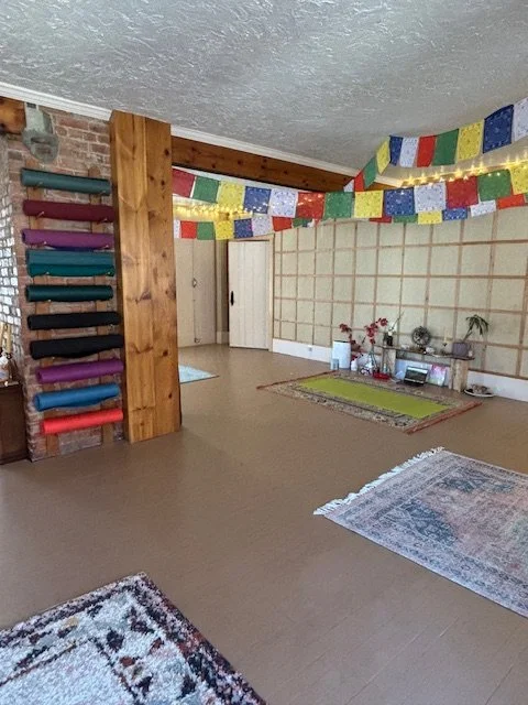abide west yoga studio, you can see the altar, yoga mats, rugs, string lights and prayer flags
