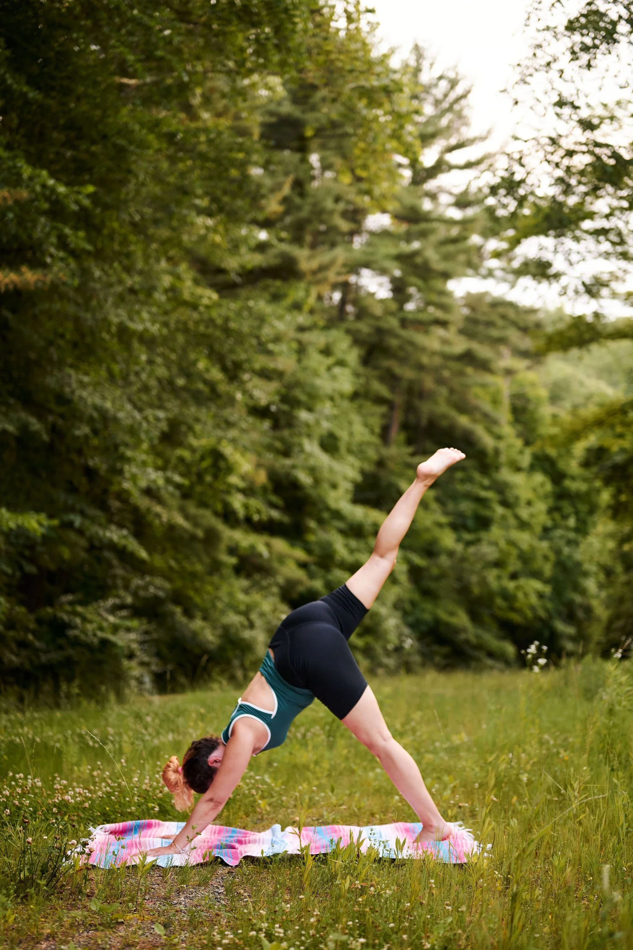 Jena doing yoga outside in three-legged dog pose