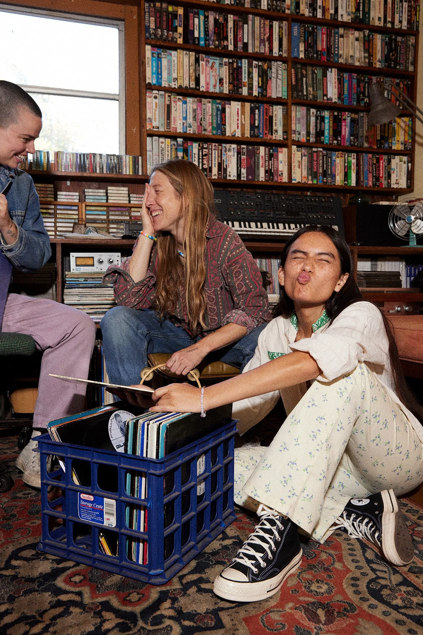 Candid lifestyle photography: friends laughing in room full of vinyl records by Tara Donne, photographer & director working in NYC & LA
