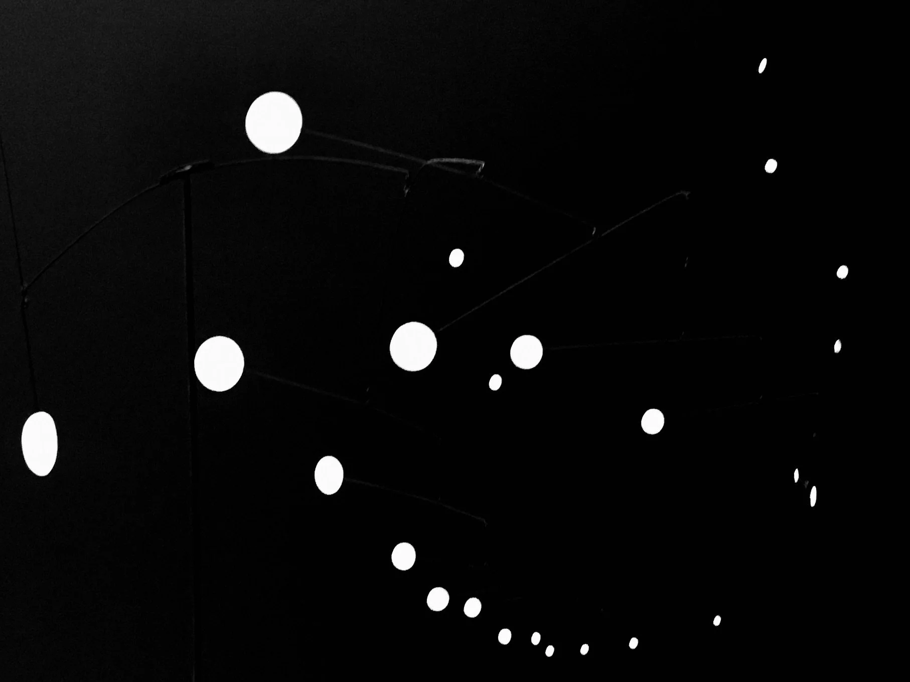 A series of illuminated circular lights arranged in a curved pattern against a dark background, creating a tunnel-like effect.