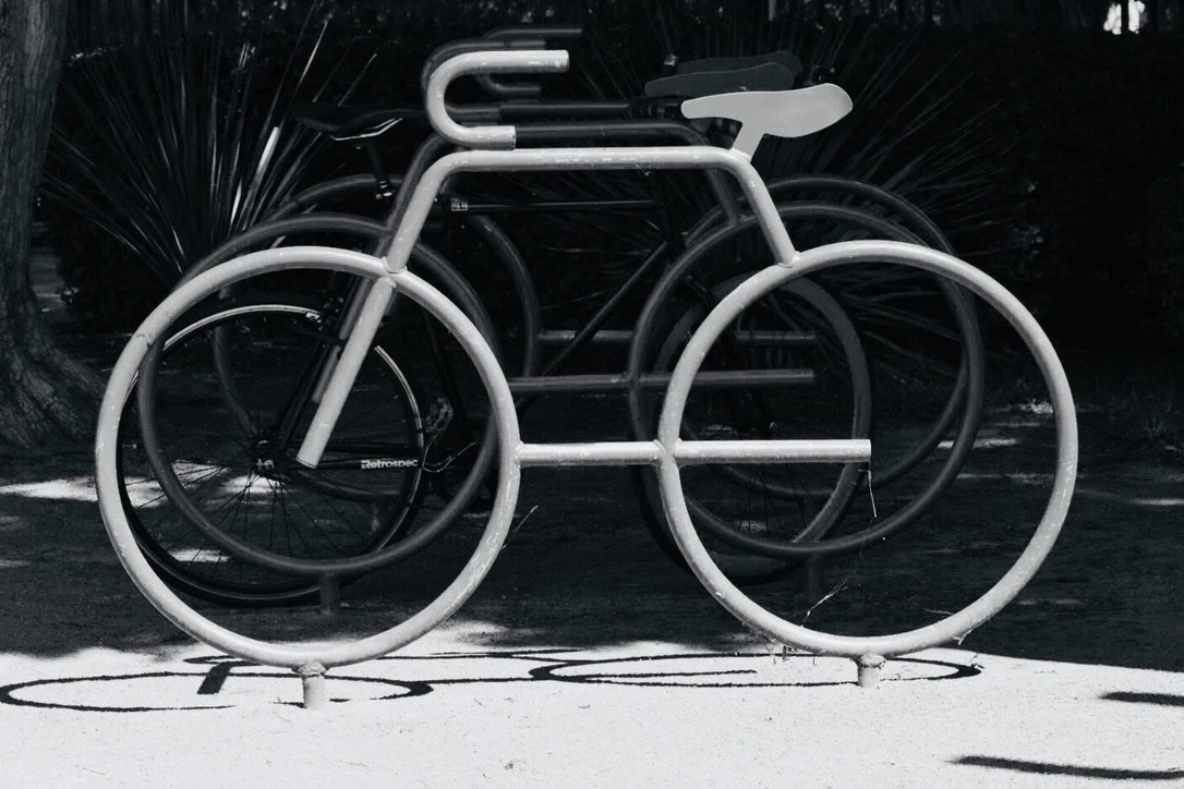 A black and white bike rack designed in the shape of a bicycle.