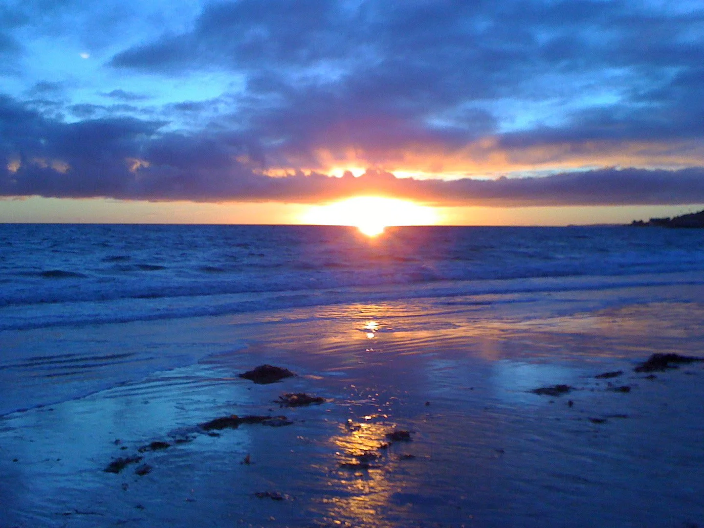 Sunset over the ocean with clouds and reflection on the water