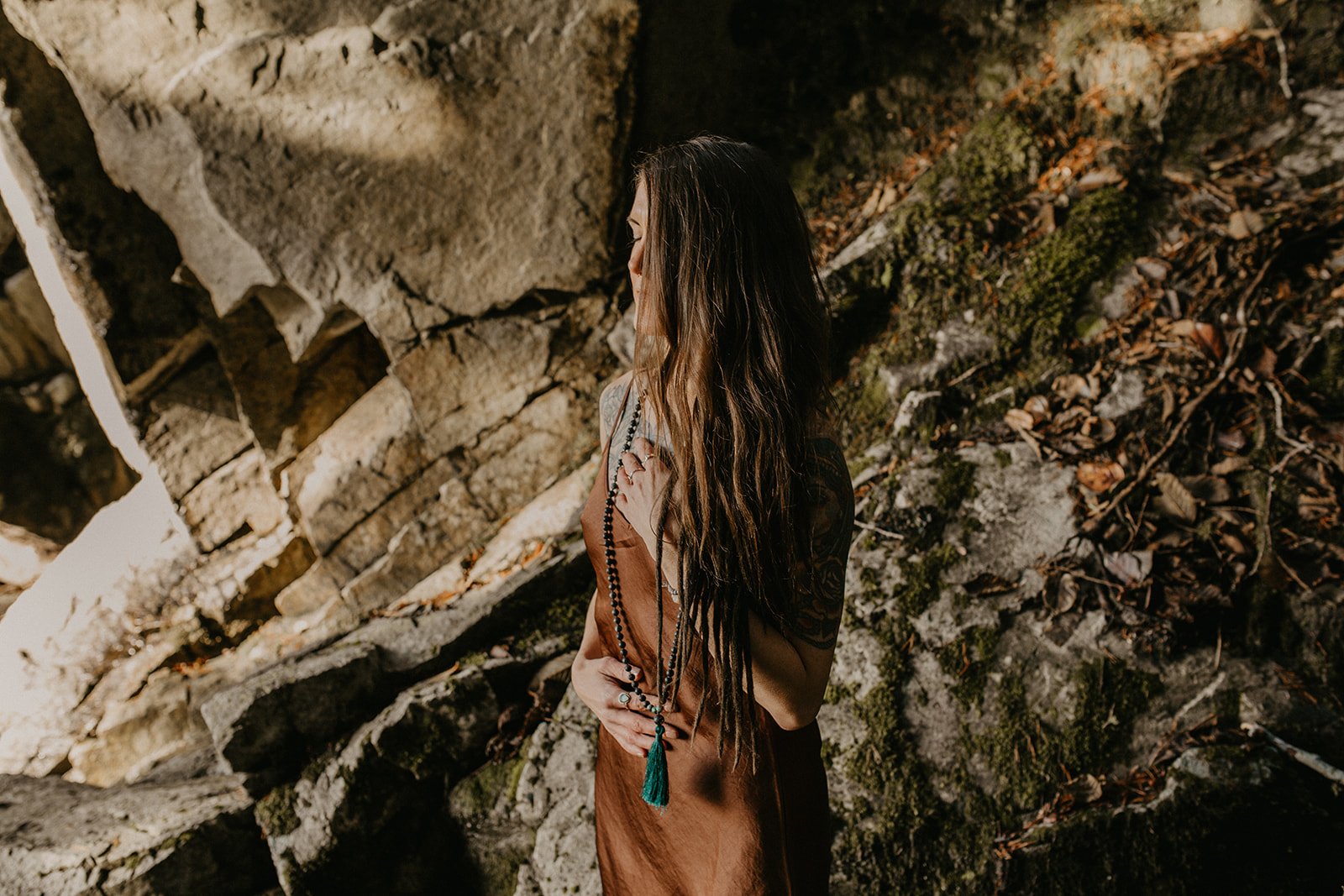 Woman meditaionn infront of rock on the west coast