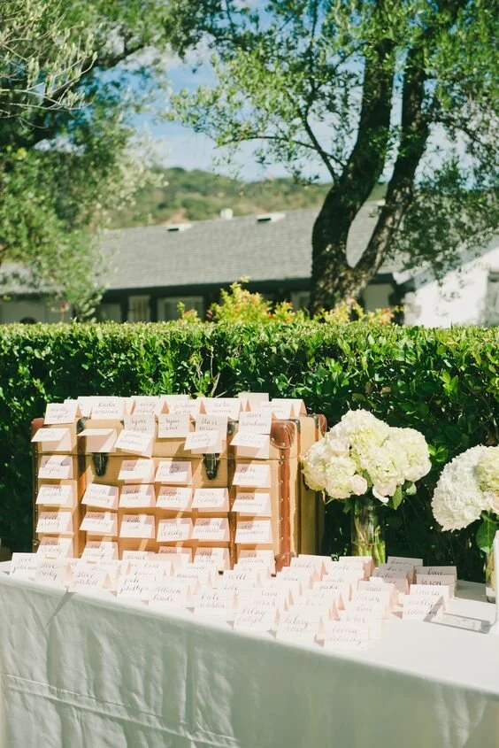 BR Cohn Winery wedding seating chart tags on a table with an old suitcase