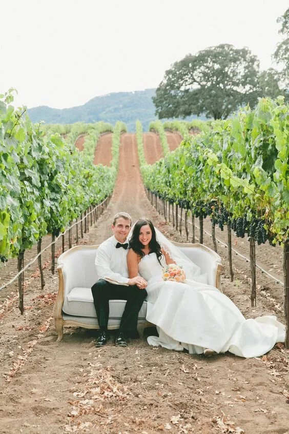 Bride and groom sitting on a white couch in the vineyards at this BR Cohn Winery wedding