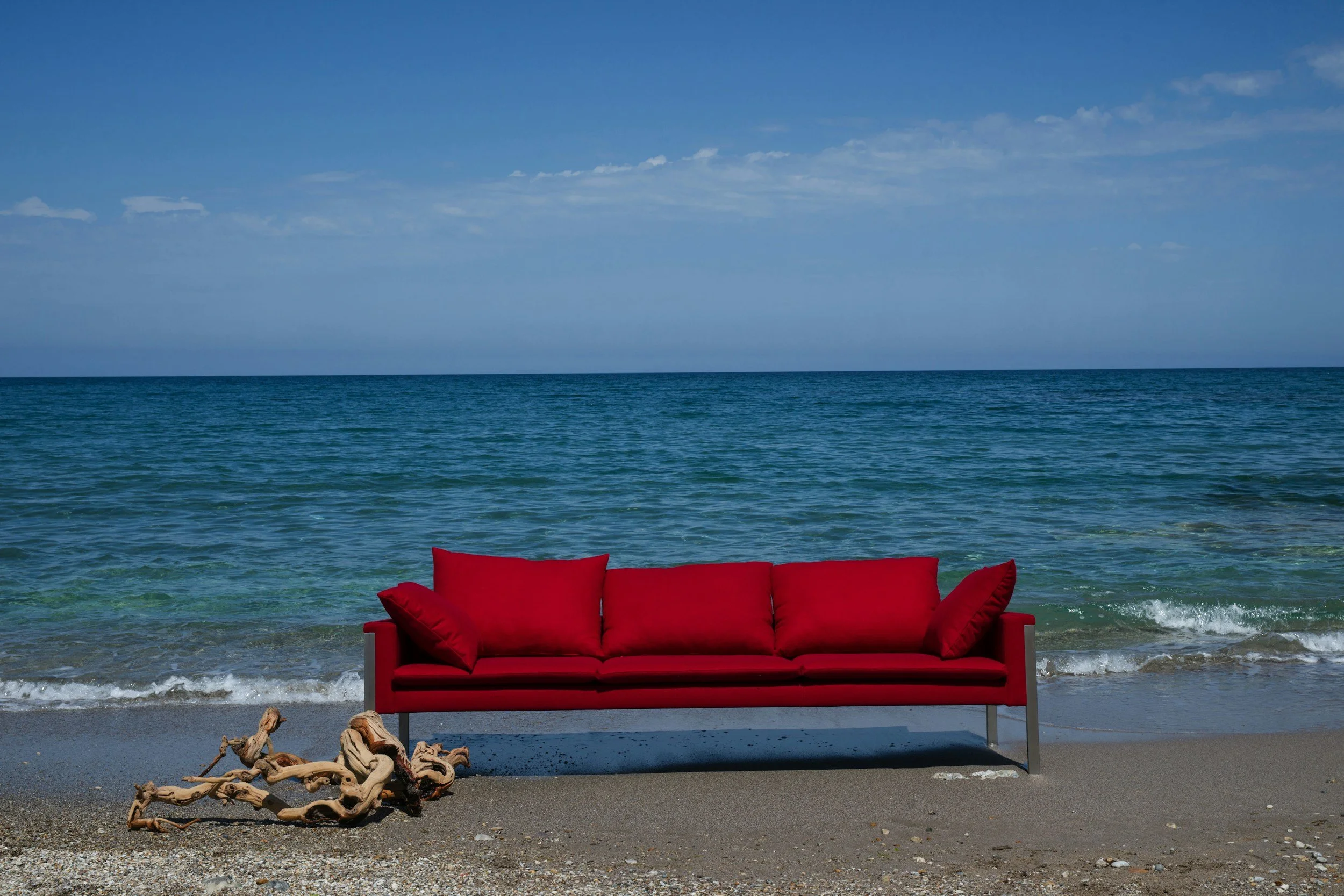 red sofa in front of the ocean