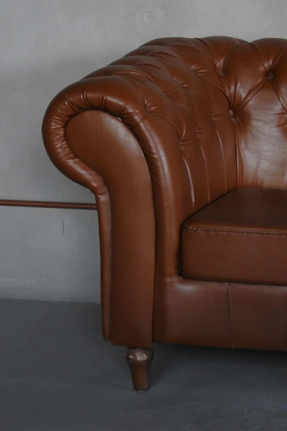 A leather sofa in a small living room, chosen over a cheaper gray sectional on sale.