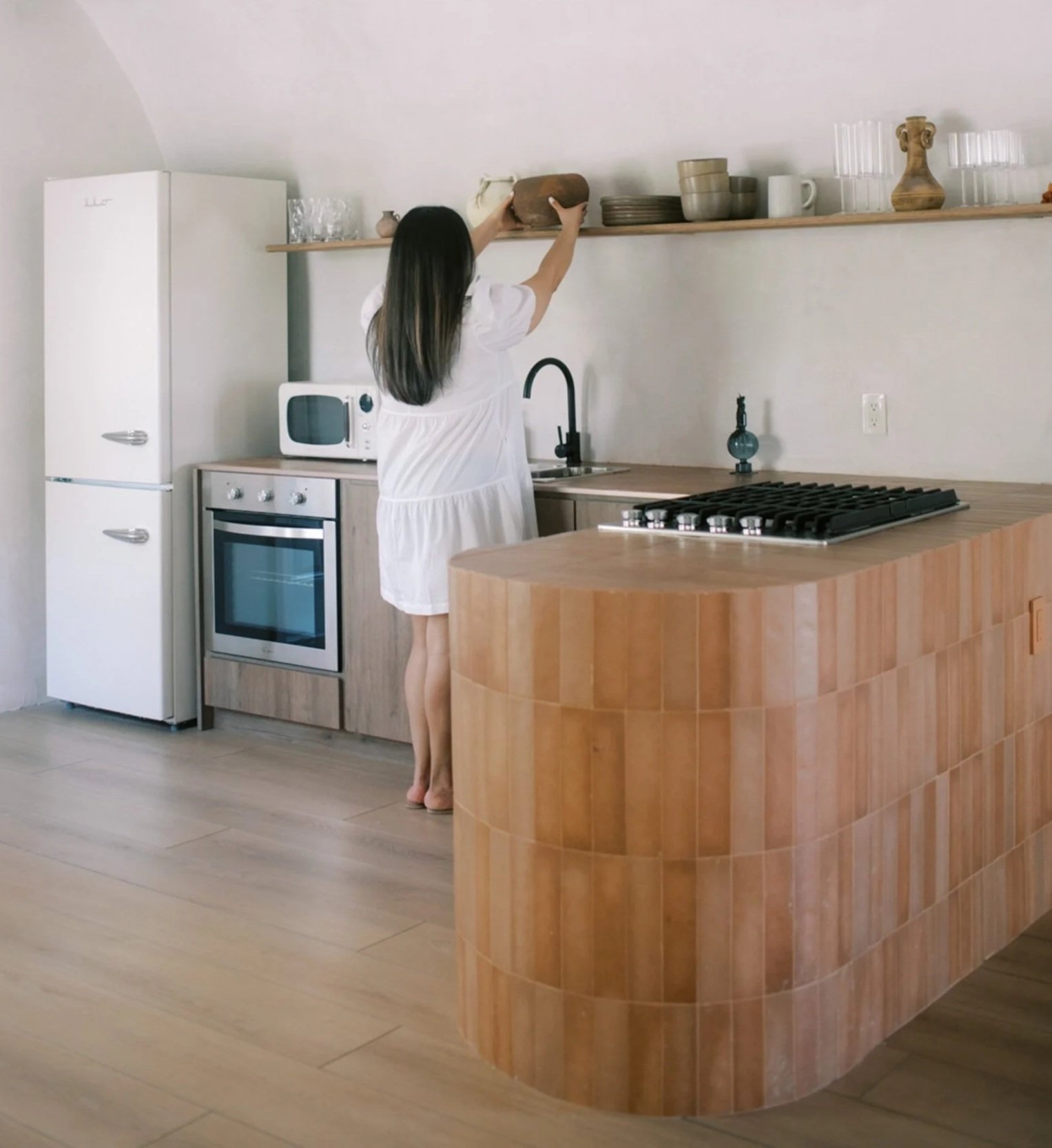 woman placing wooden bown on shelf in calm minimal kitchen-Design Mood Done Moves action plan by ARDISENOSTUDIO