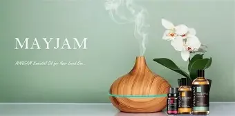 May Jam natural essential oils with a wooden diffuser, white orchid, and bottles of essential oils on a pale green background.