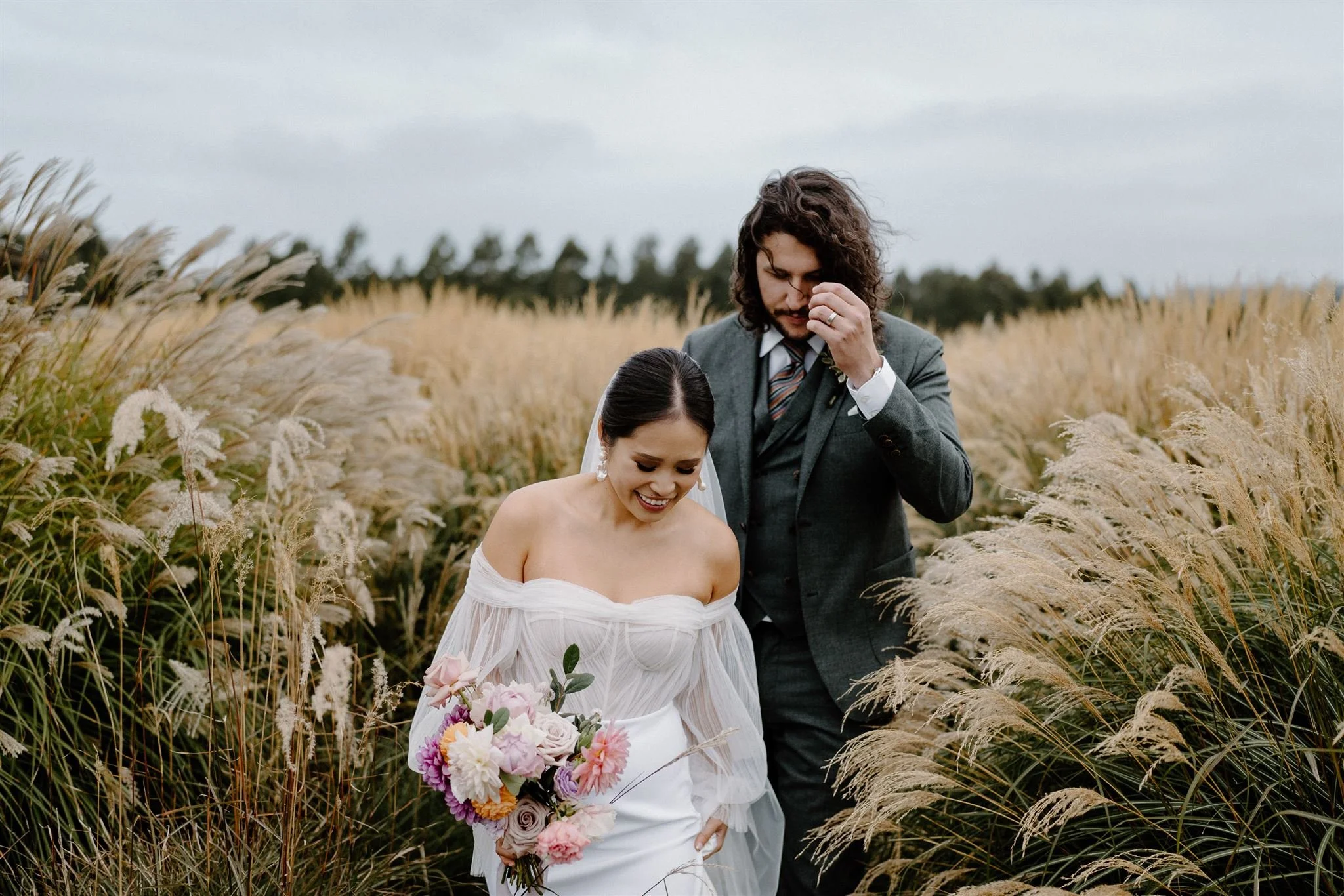 Bride and Groom walk along the tall grass at Bendooley Stables in the Southern Highlands NSW