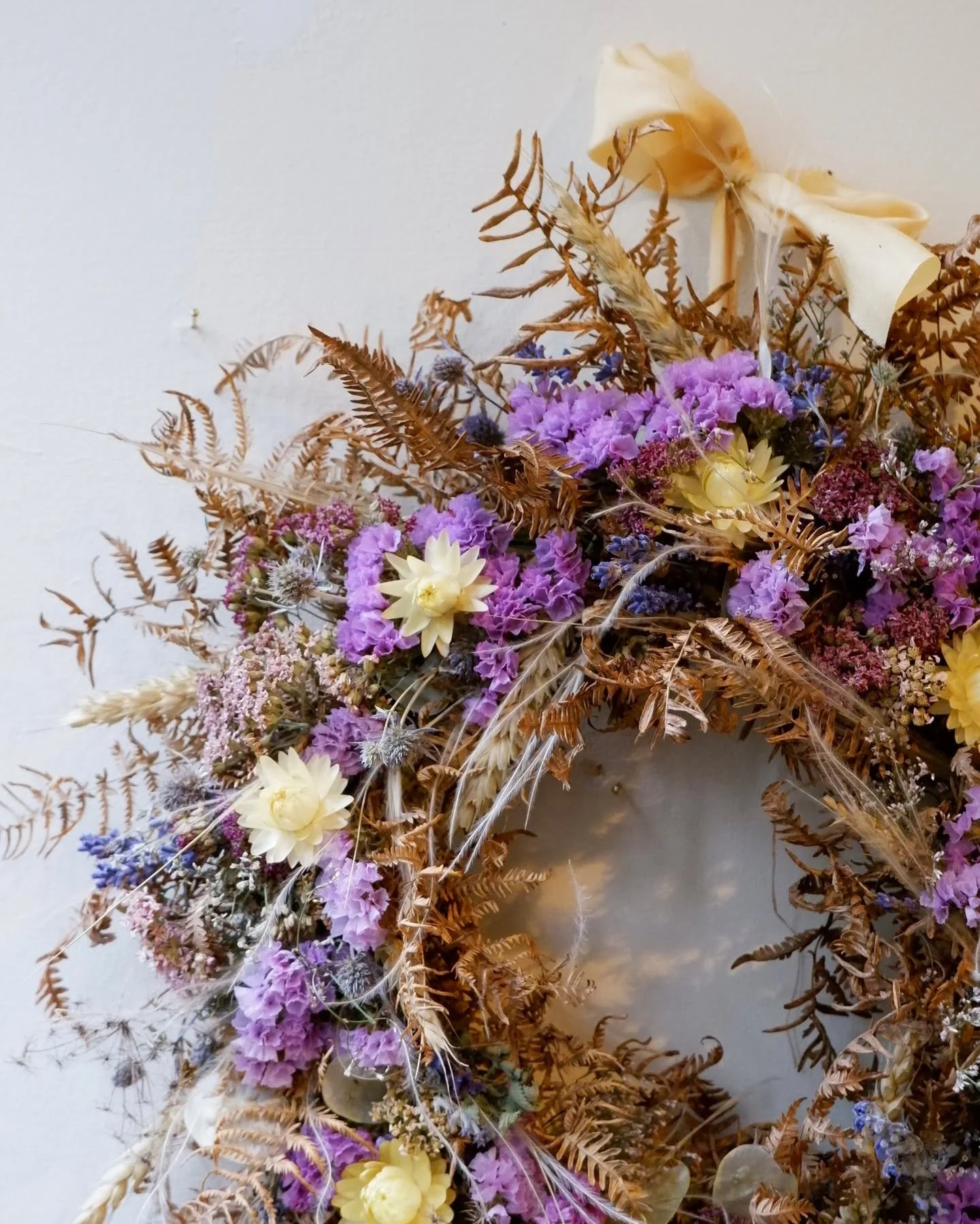 There's something hypnotic about carving that circle with repeating flowers, in creating it and perceiving.

Bespoke wreath in pale yellow, lilac, and neutrals. 

Extra note: I love how the botanical dye in the silk ribbon here is almost the exact sa