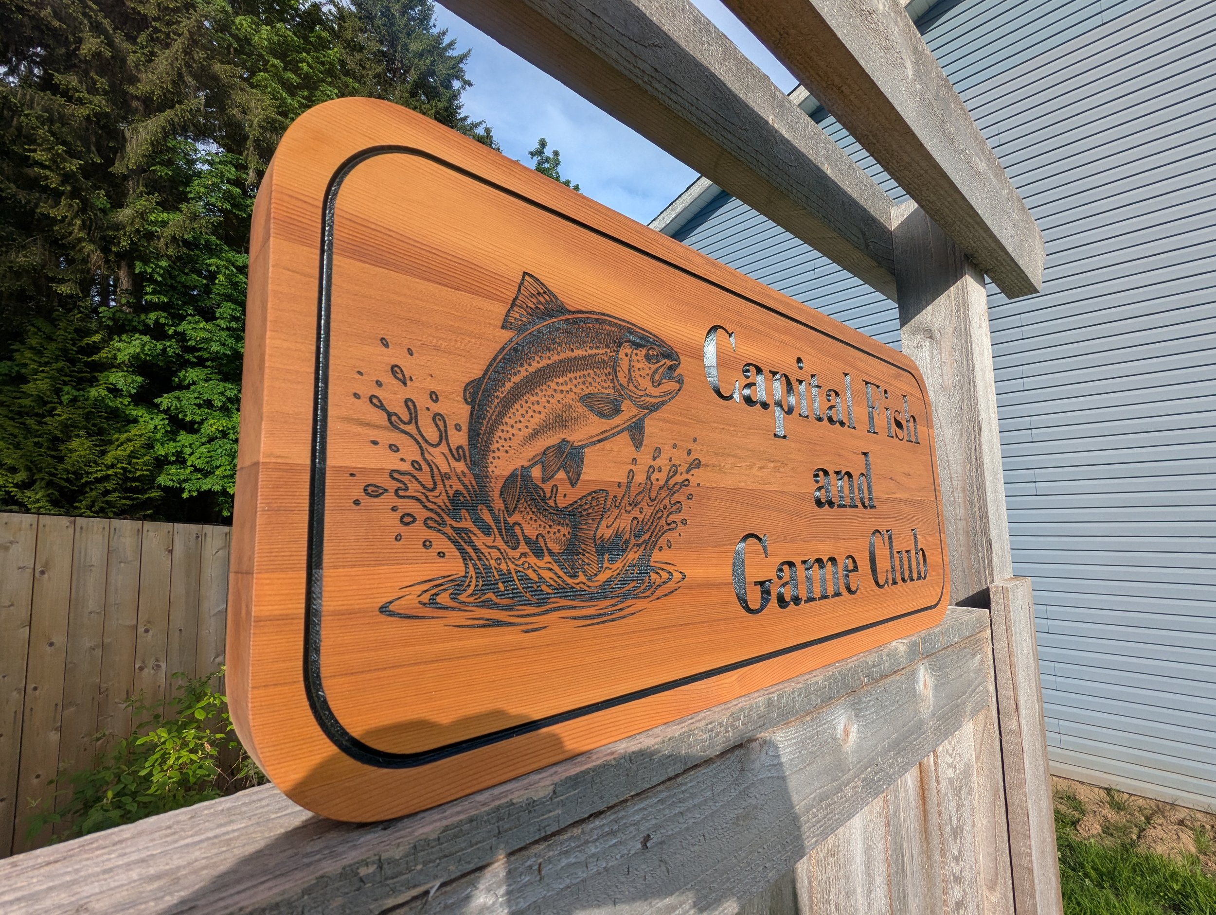 Capital Fish and Game Club Sign made from cedar with black lettering and engraved bass jumping out of water