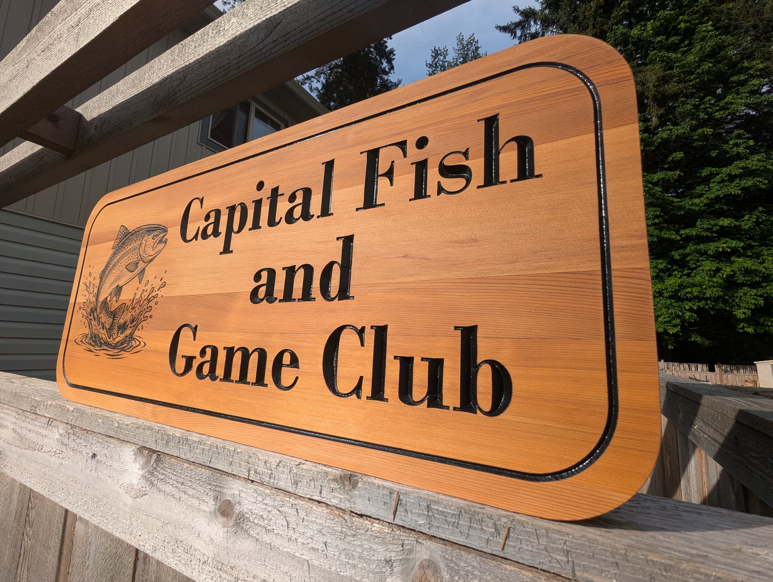 Capital Fish and Game Club Sign made from cedar with black lettering and engraved bass jumping out of water