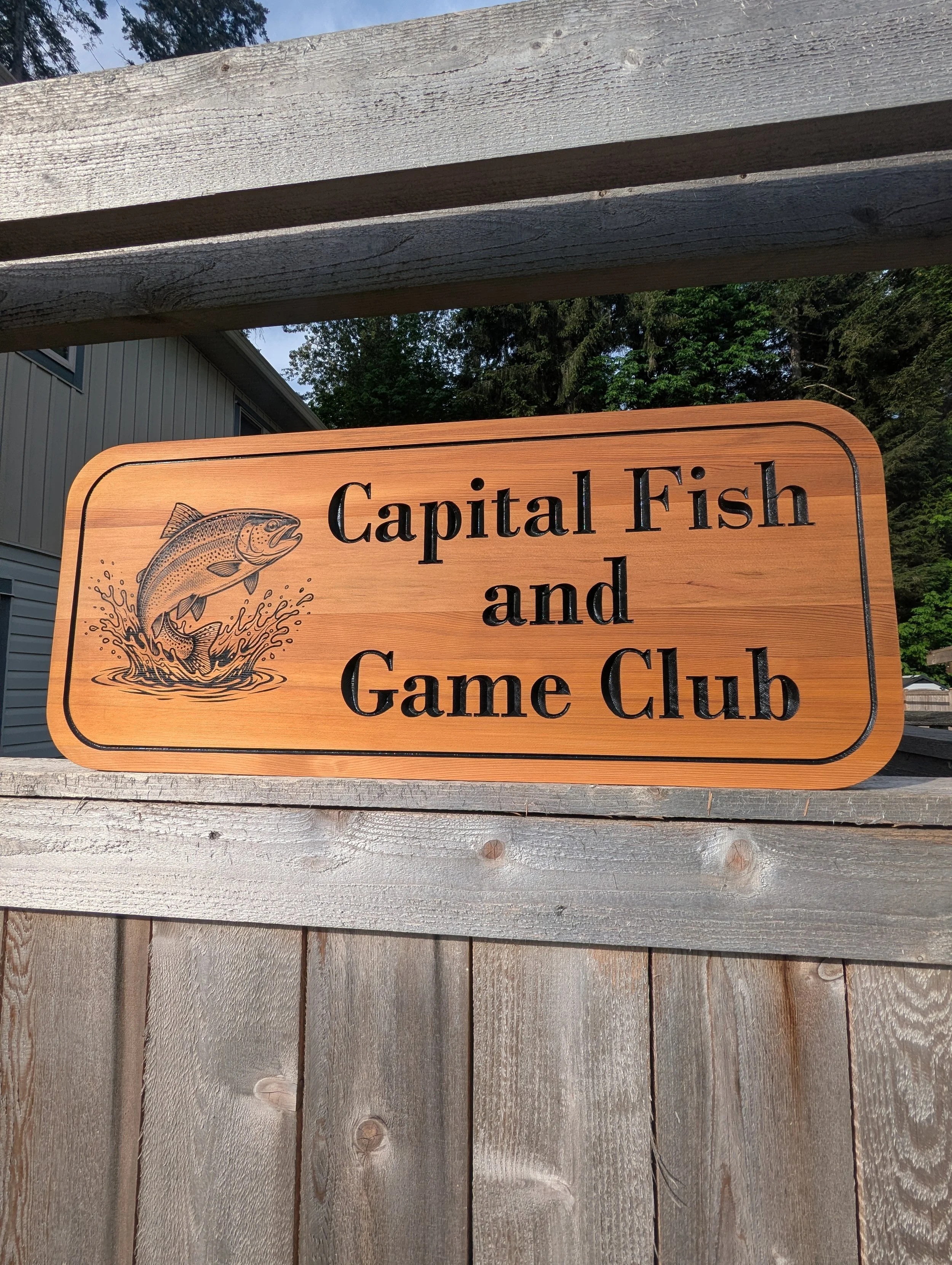 Capital Fish and Game Club Sign made from cedar with black lettering and engraved bass jumping out of water