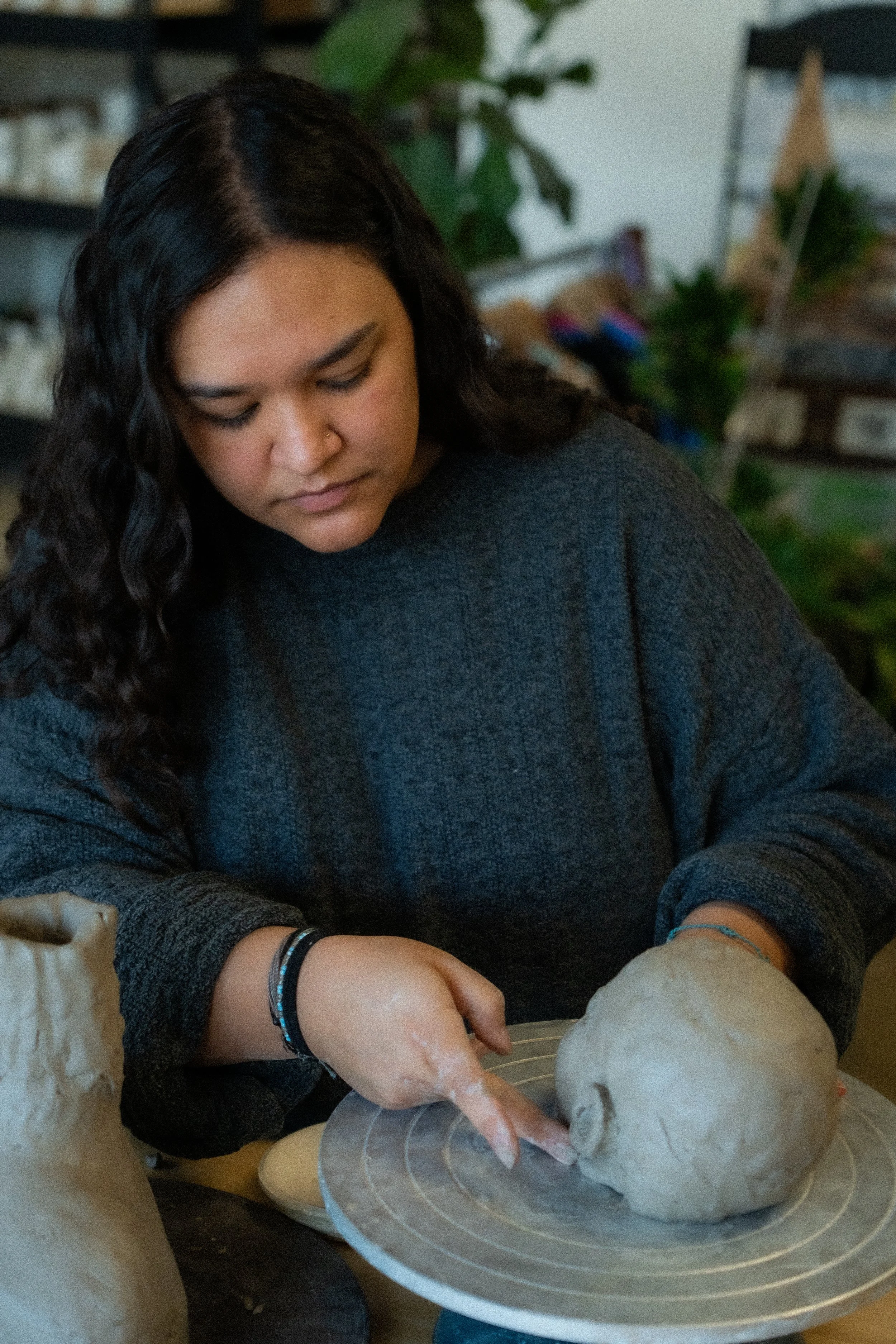 Syd Butts MFA pottery and ceramics instructor teaching wheel throwing class at The Art House St. Augustine Beach Florida