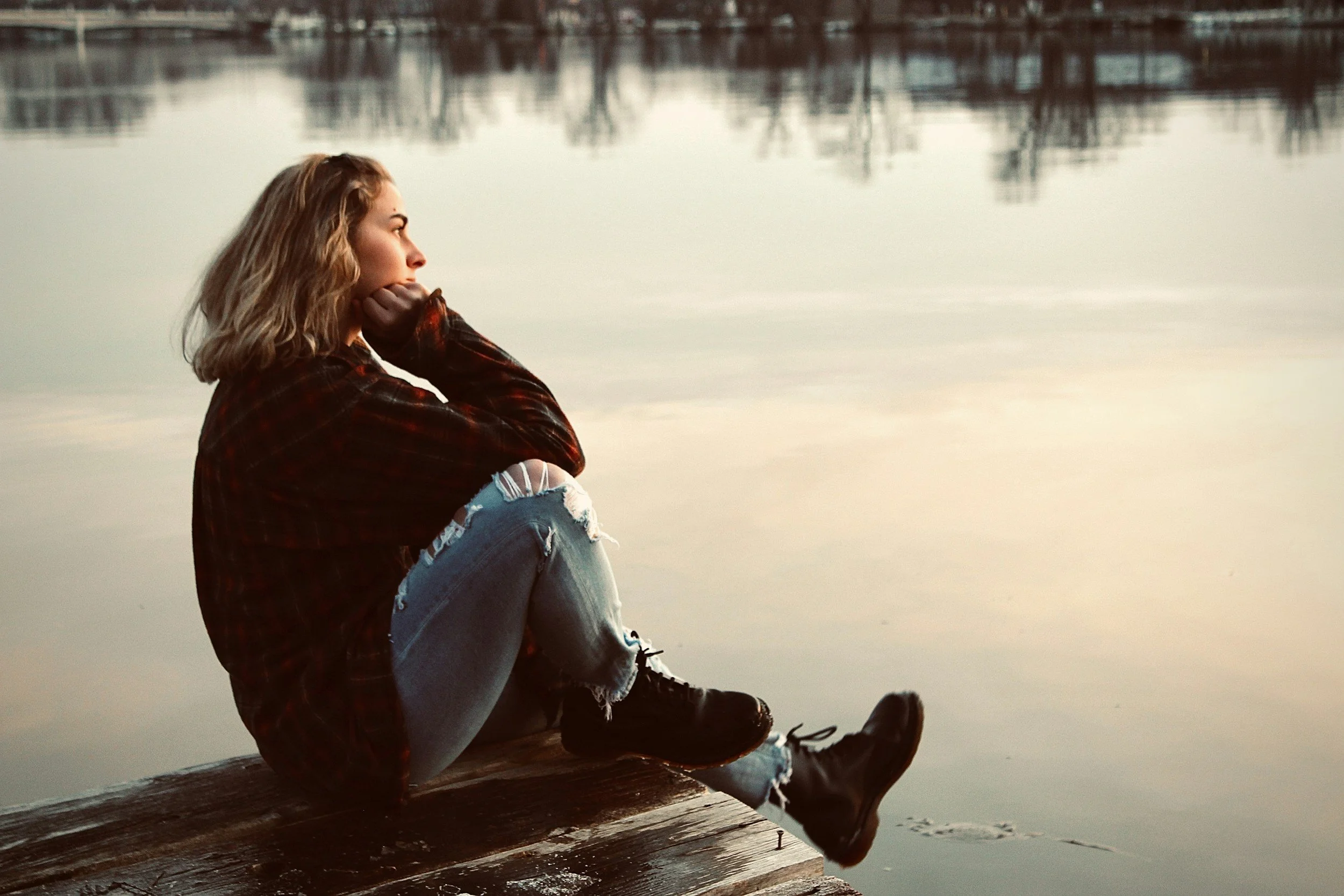 Woman in her 40s sitting quietly and looking inward, representing the resurfacing of earlier experiences during midlife transition