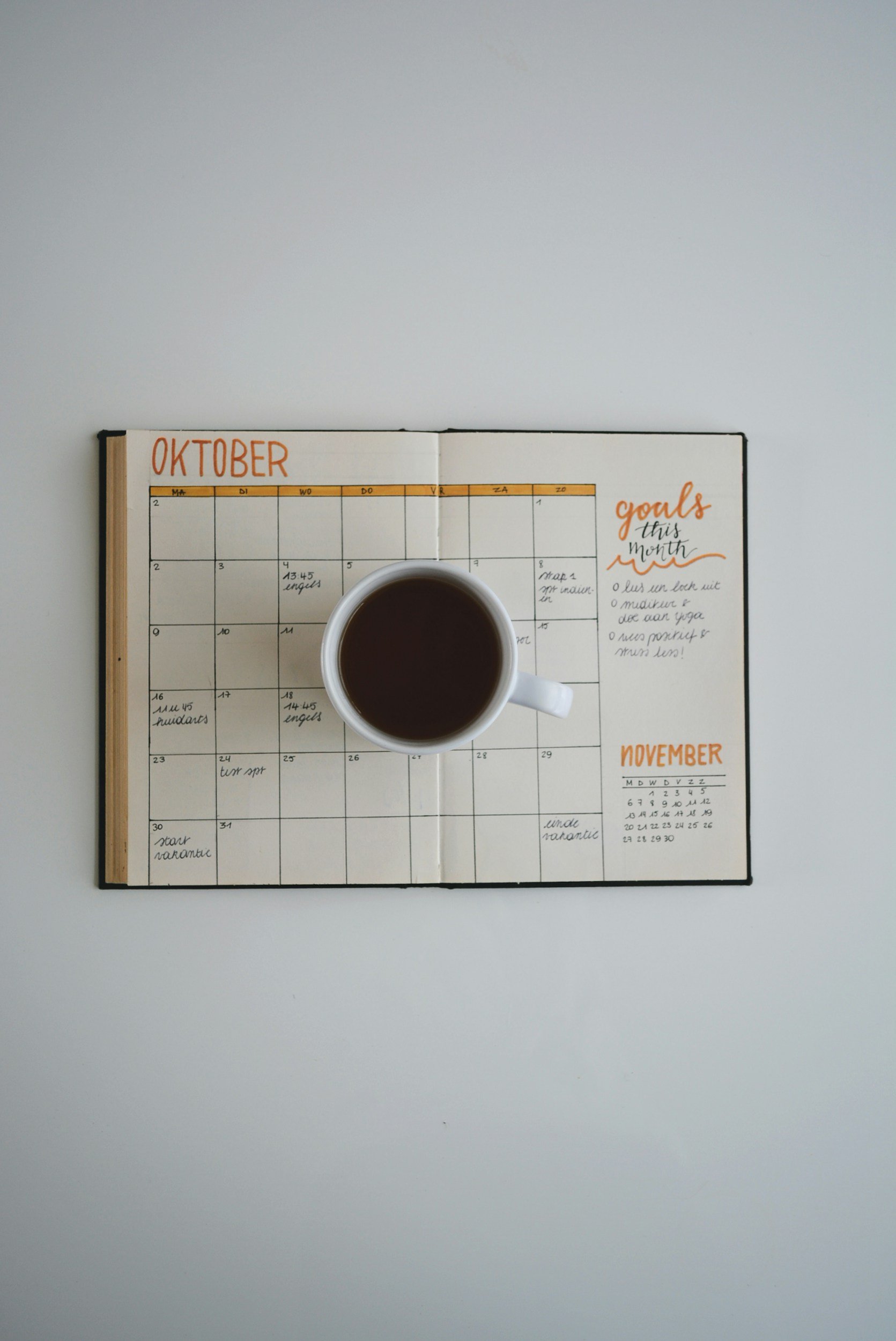 A calendar and coffee cup on a table, representing the return to a fall schedule