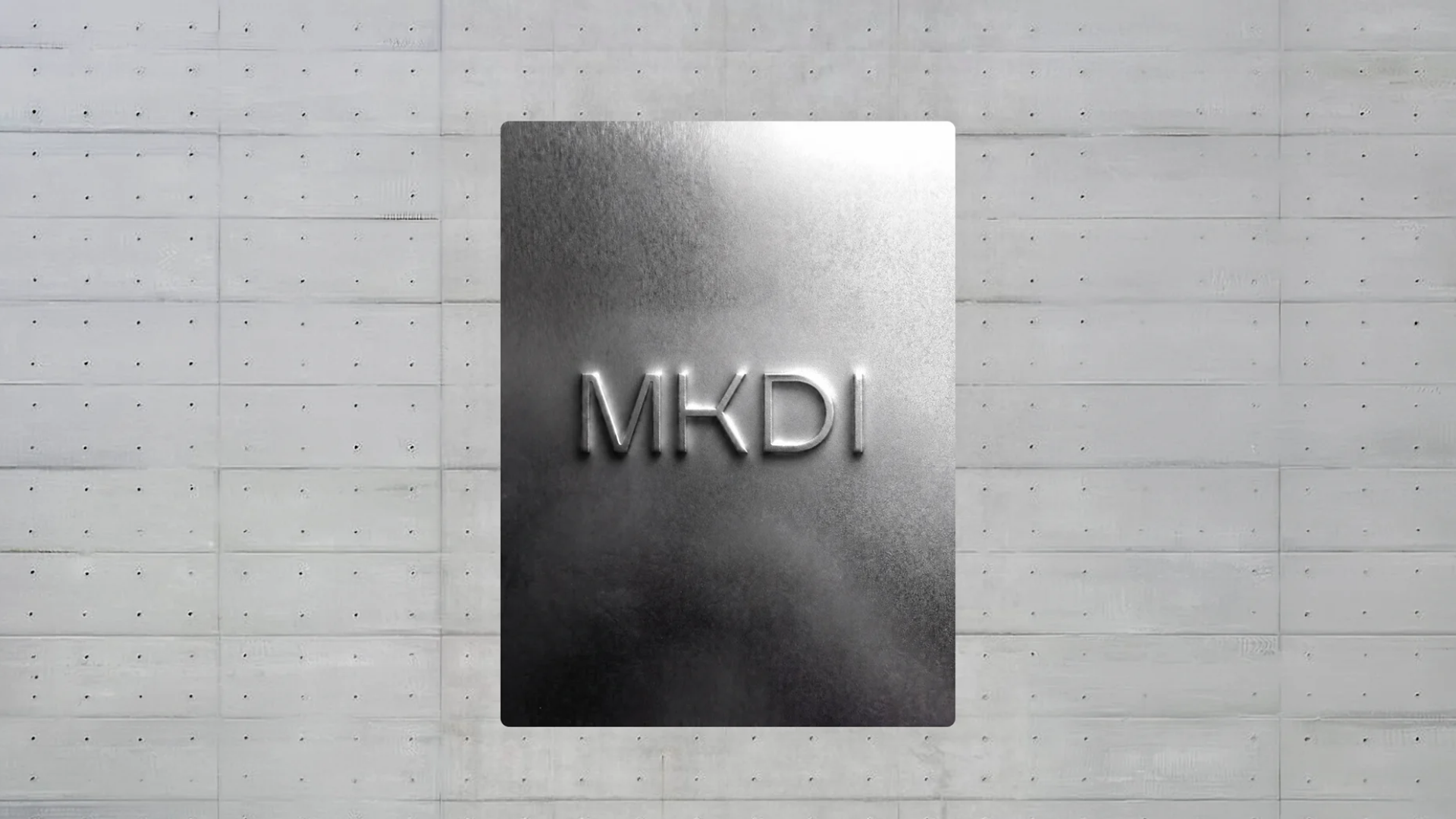 MKDI monogram embossed on a concrete wall