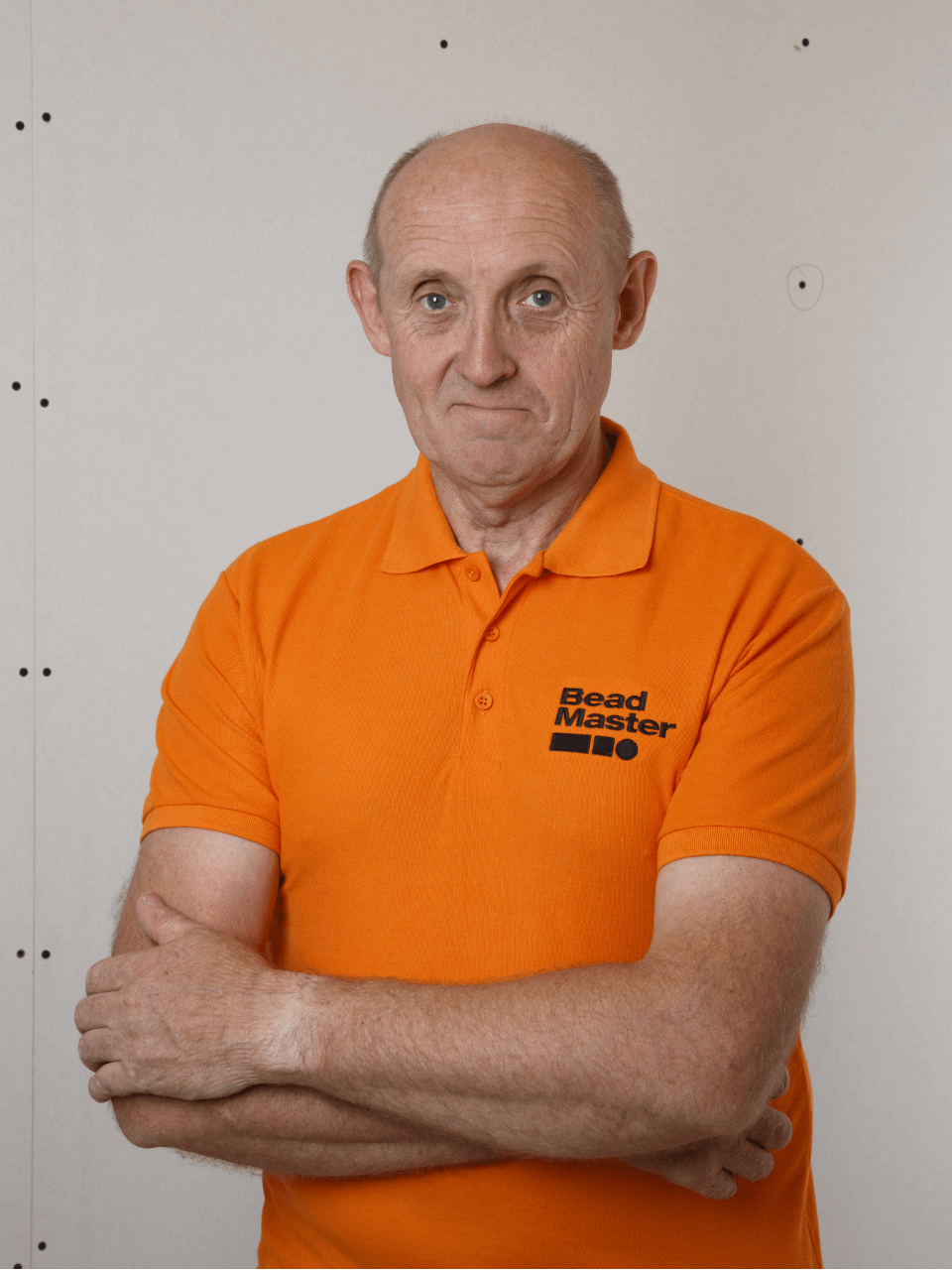BeadMaster inventor, Peter Carter, sorting a bright orange branded polo shirt.