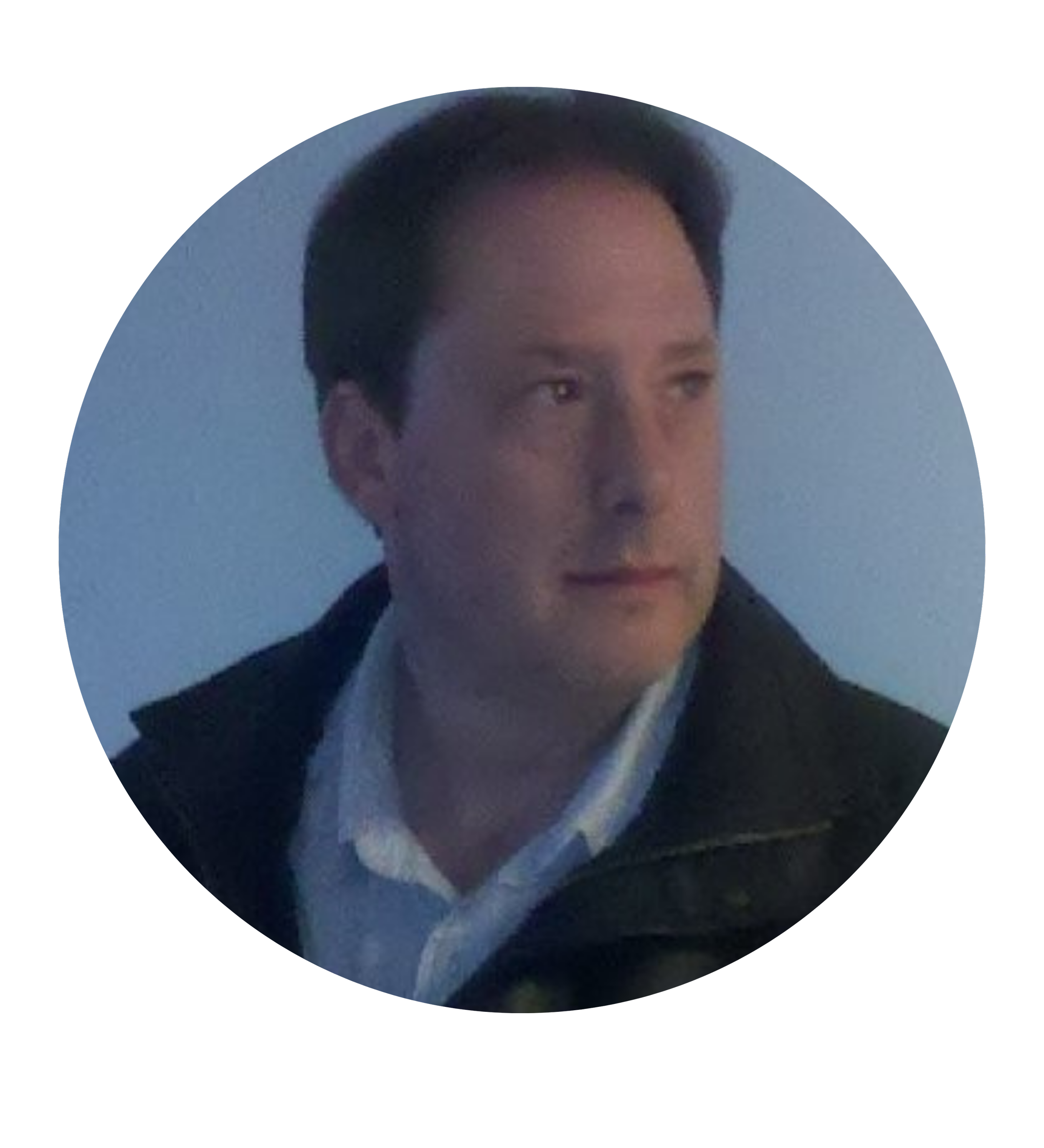 A smiling man with short dark hair and a light-colored shirt.