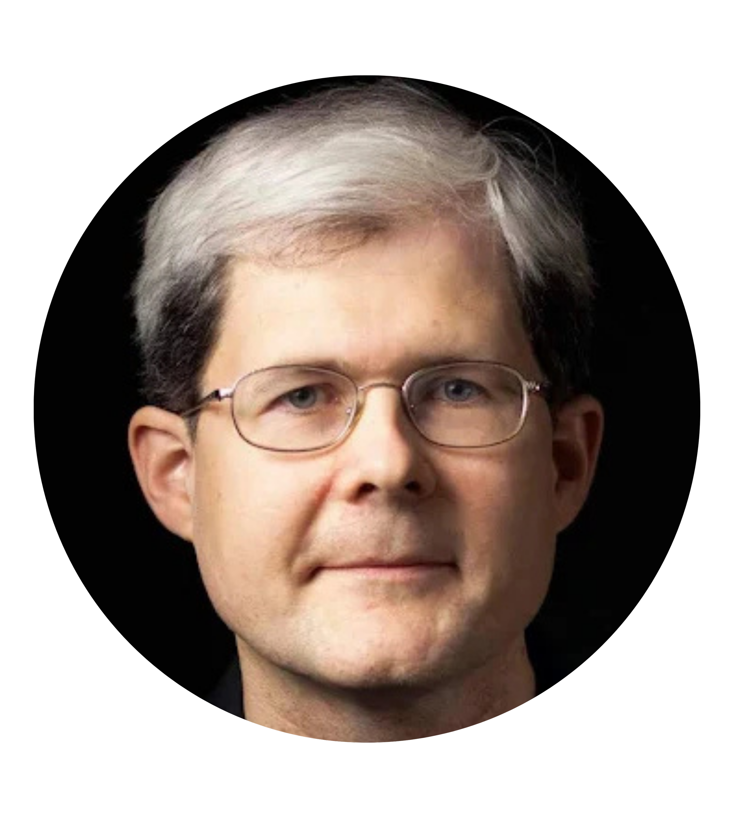 Close-up portrait of a man with light skin, short gray hair, glasses, wearing a black shirt, against a black background.