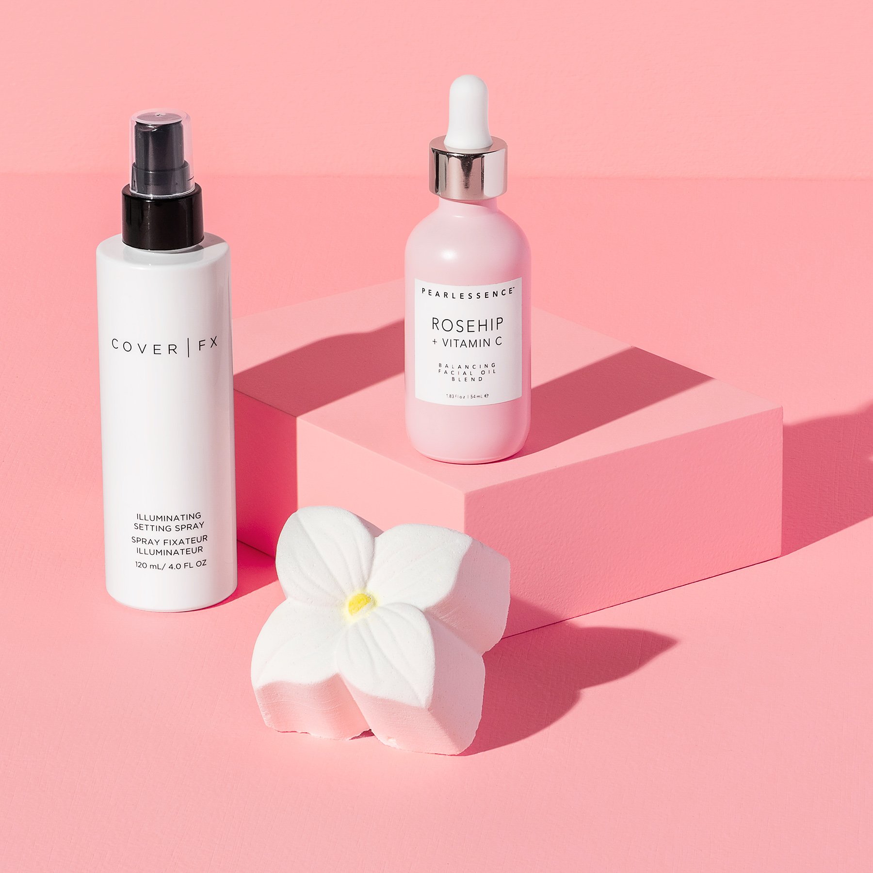 One rectangular pink product photography riser displaying bottles of perfume