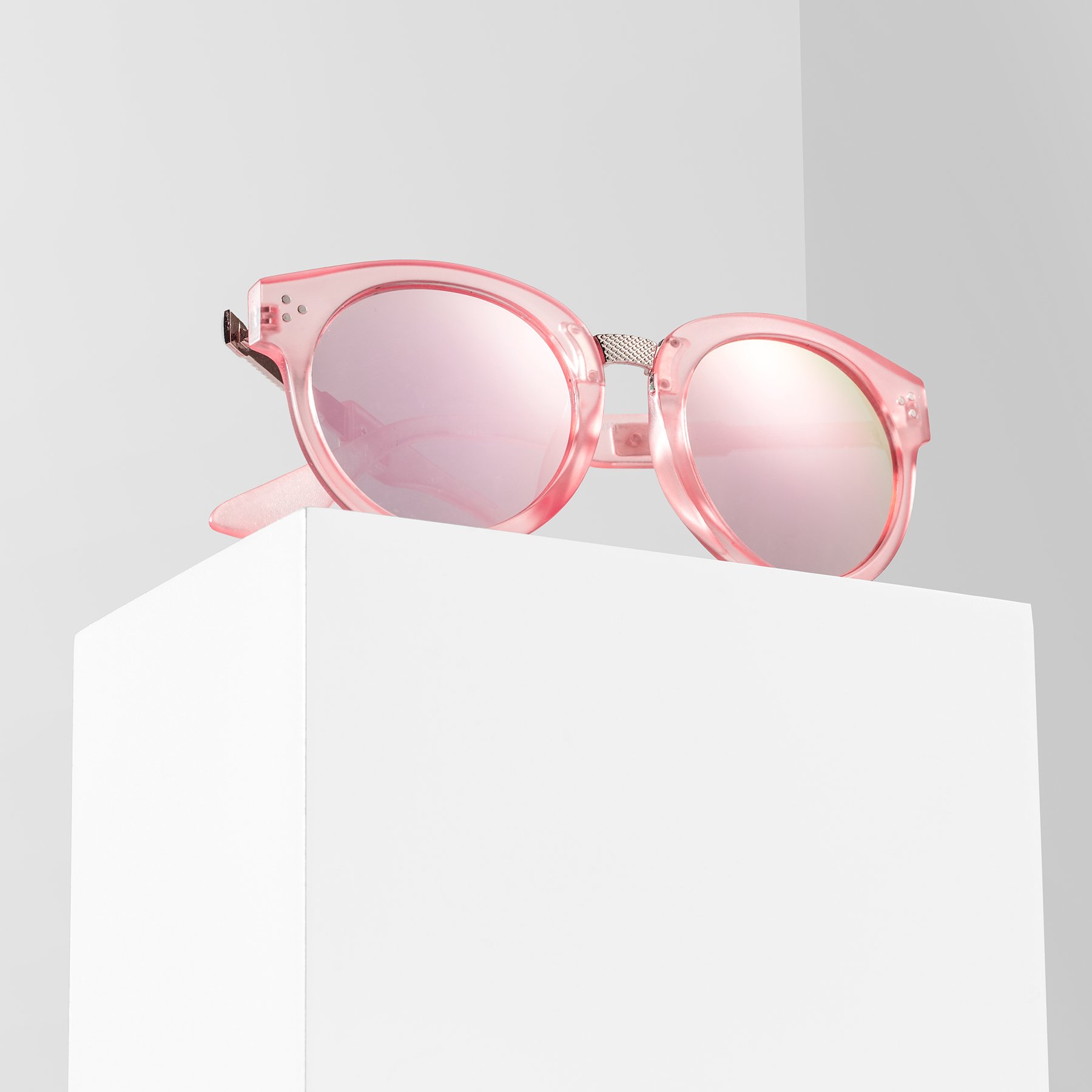White product photography riser displaying pink sunglasses