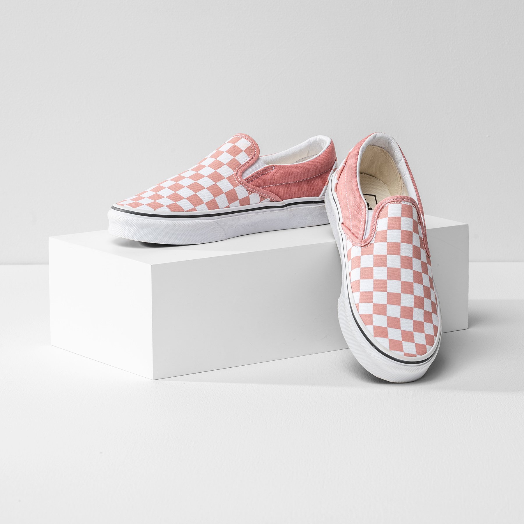 One white product photography riser the size of a shoebox, displaying a pair of pink shoes