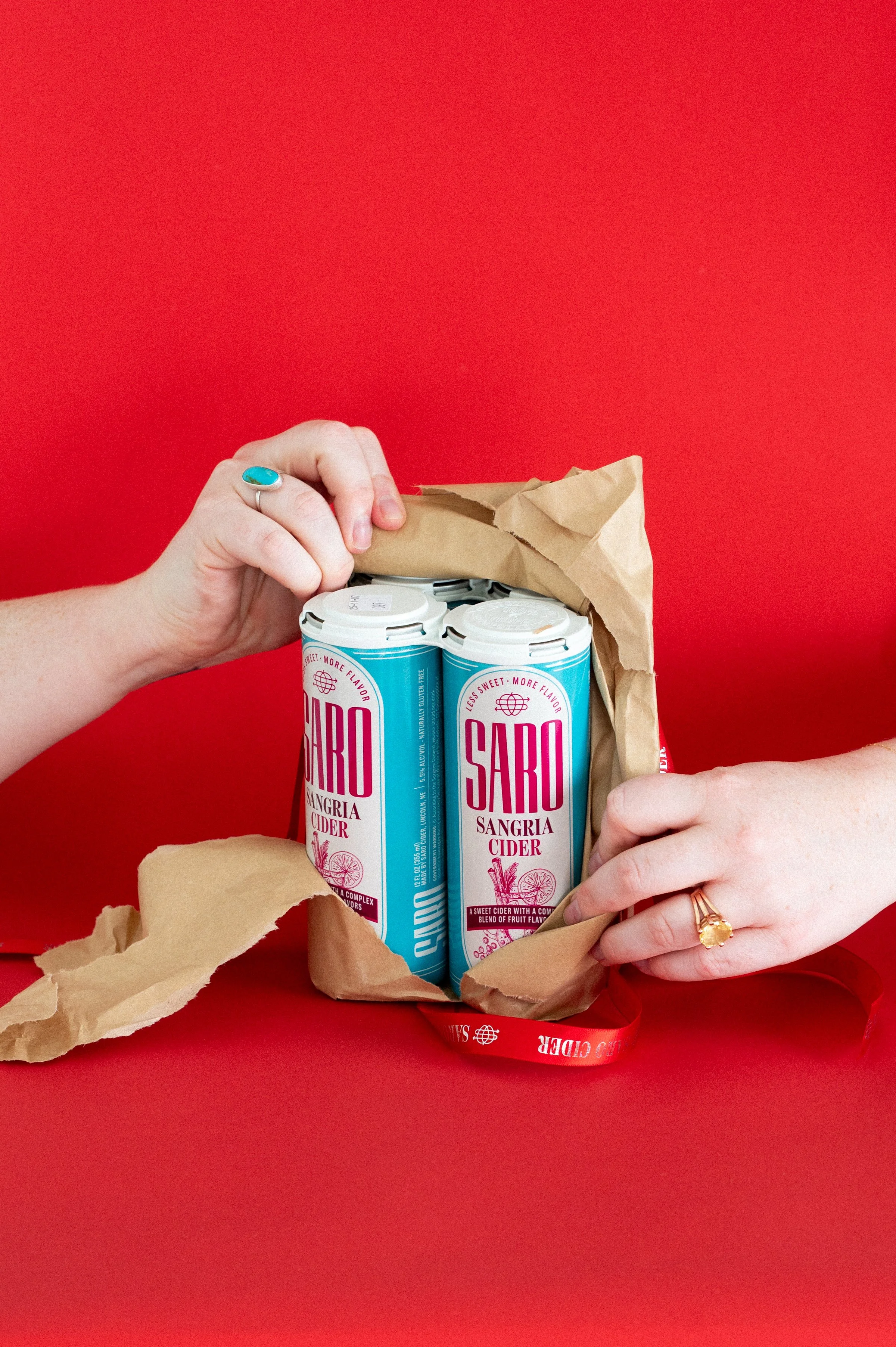 People enjoying a picnic with Saro Cider in a cooler filled with ice outdoors. Explore Saro, Explore More!