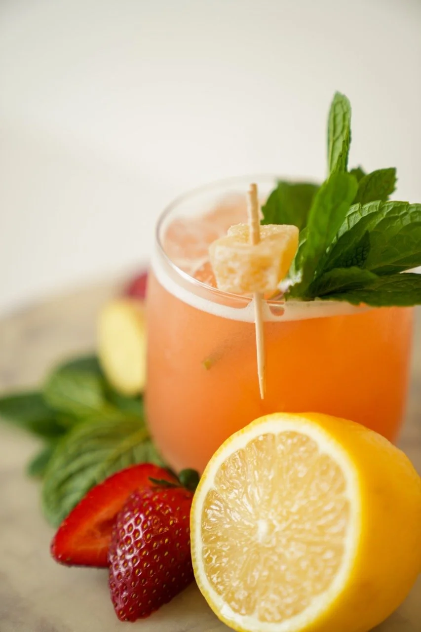 A fruity cocktail with fresh ingredients like lemon, strawberries, and mint