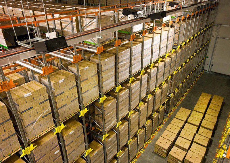 Multi-level high-density pallet storage system with integrated automation technology and yellow safety barriers