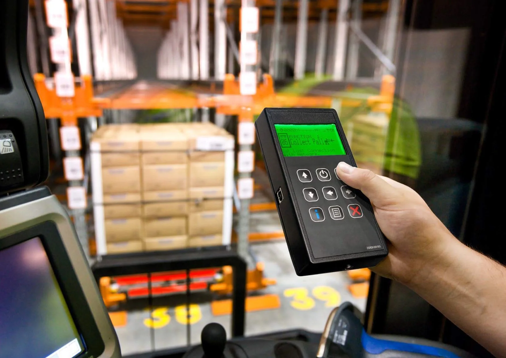 Warehouse operator using handheld digital controller with LCD screen for automated shuttle system management