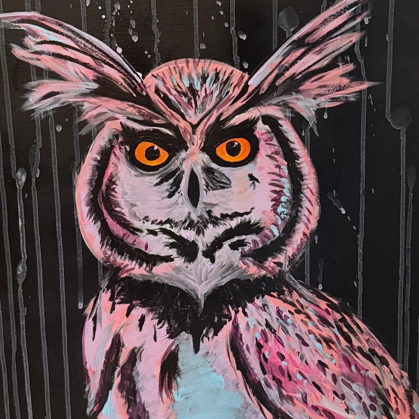 A painting of an owl with pink, black, and white feathers and bright orange eyes, set against a black background with drips of paint.