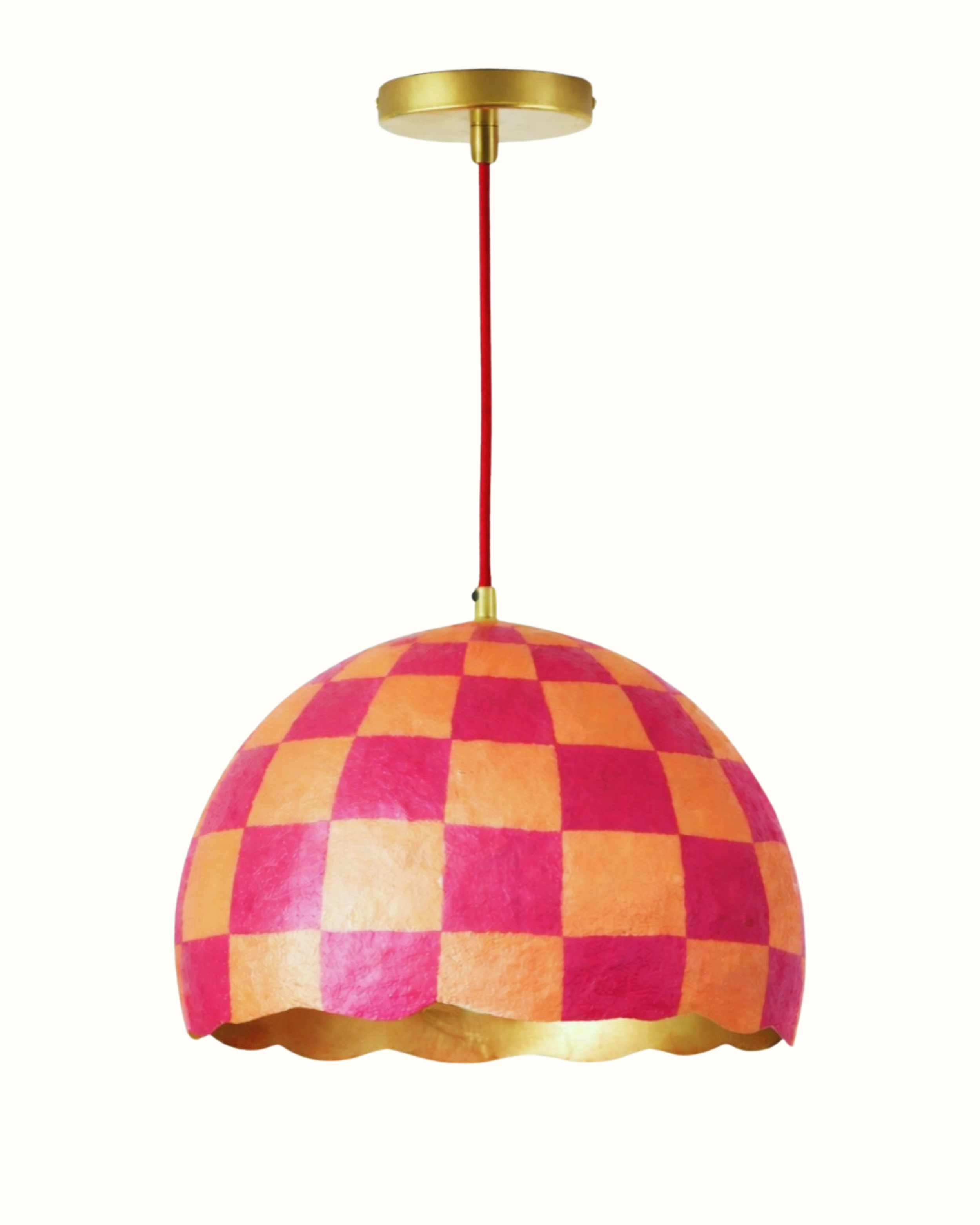 Colorful checkered pendant lamp with pink, orange, and red squares hanging from a ceiling mount.