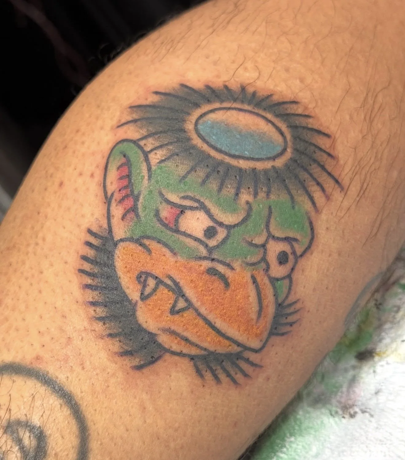 Colorful tattoo of a lion with a sunflower on its head, on a person's arm.