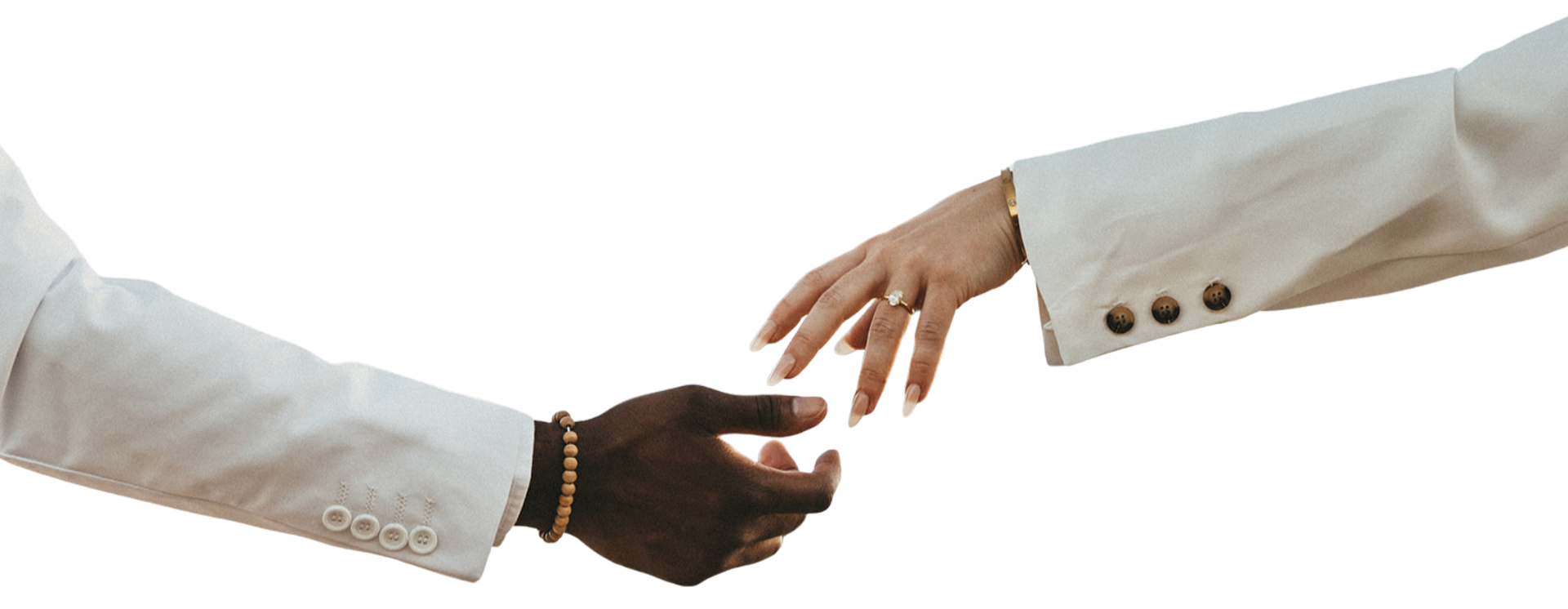 Two people exchanging a handshake, one with dark skin wearing a white blazer and the other with light skin wearing a white blazer, with visible hand jewelry.