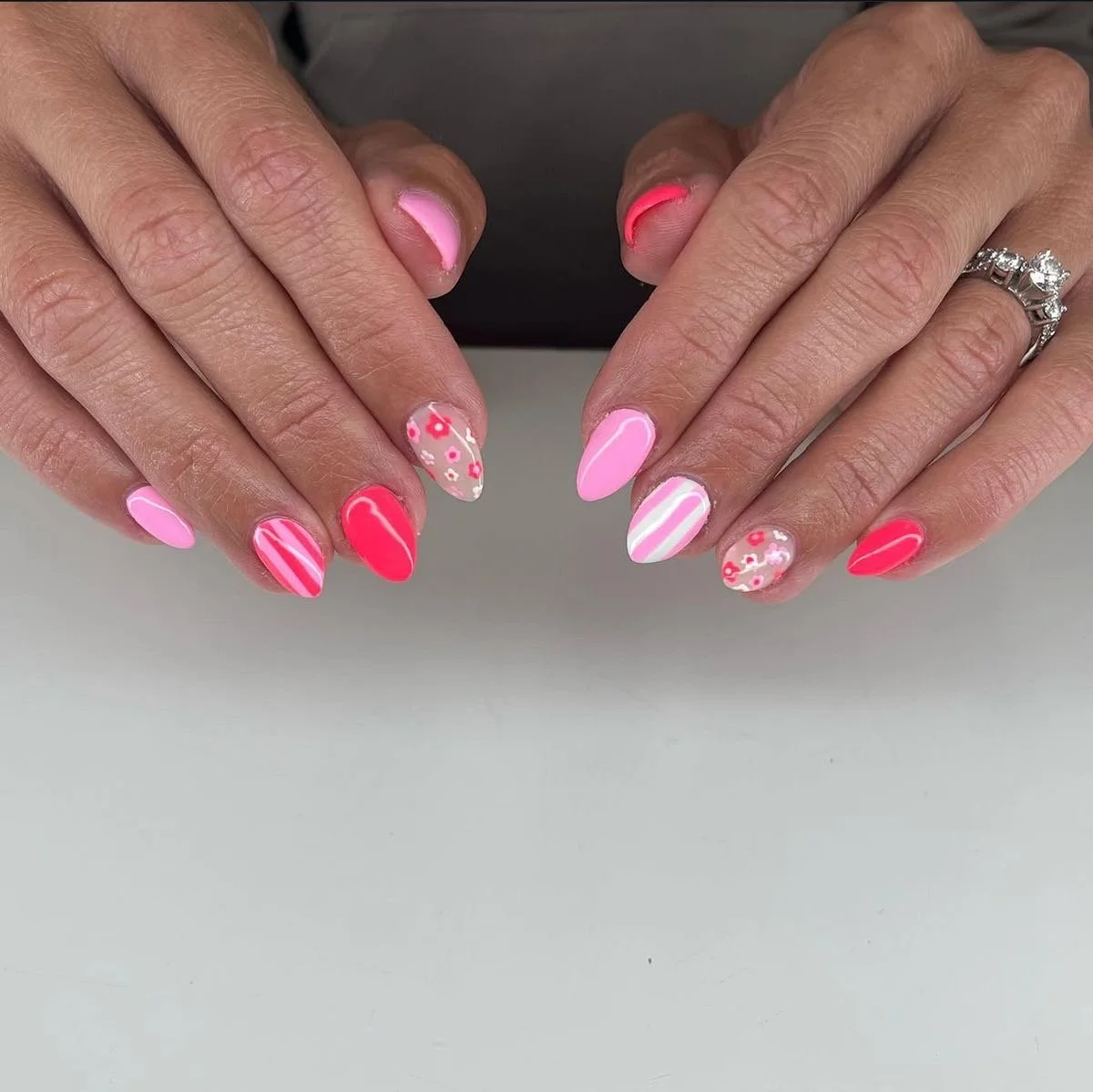 Close-up of manicured nails with pink polish and silver glitter accents.