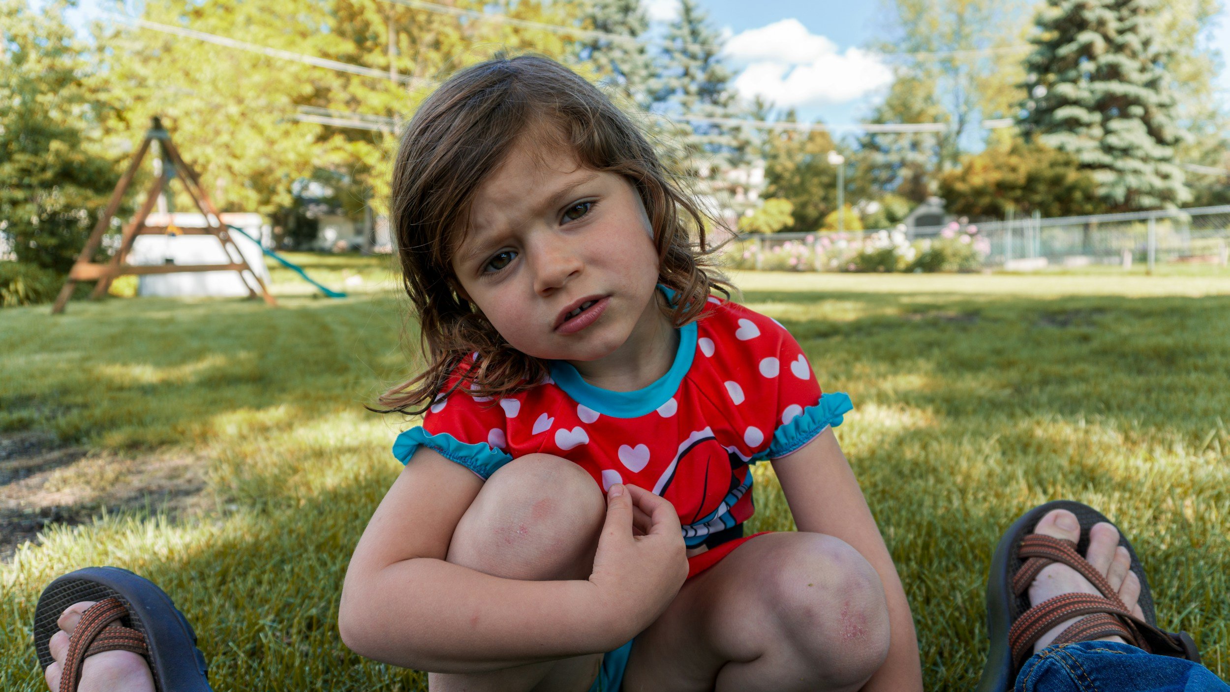 Young child with big emotions sitting outside, representing challenging behavior and emotional dysregulation in kids.