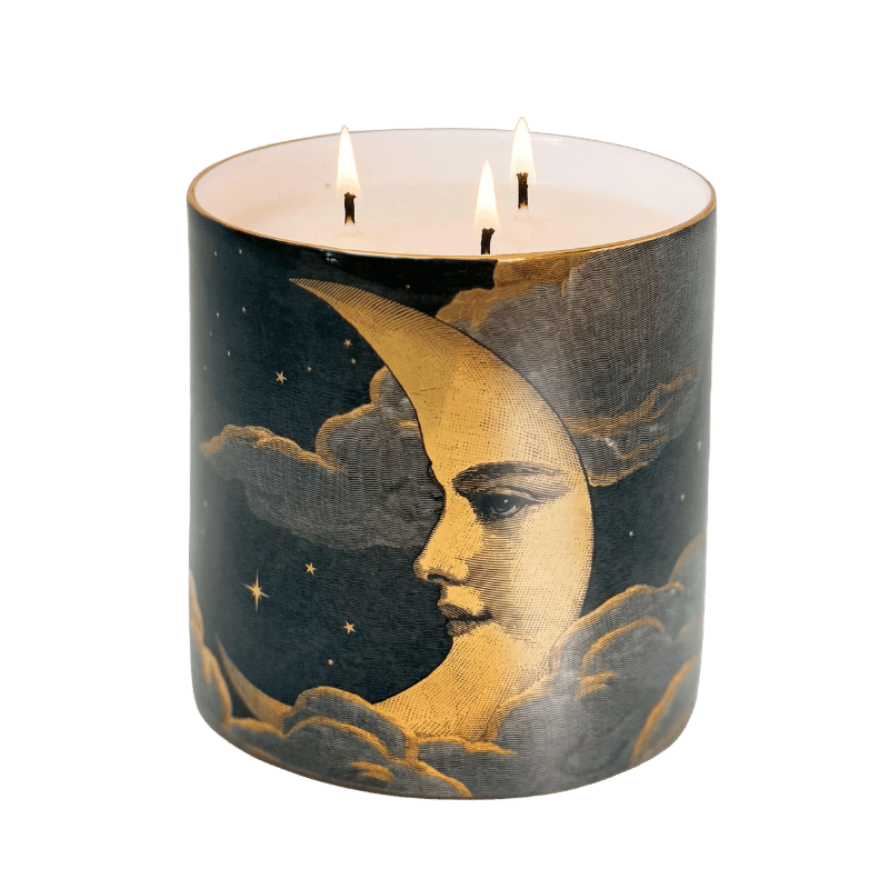 A scented candle with a moon face painted on it