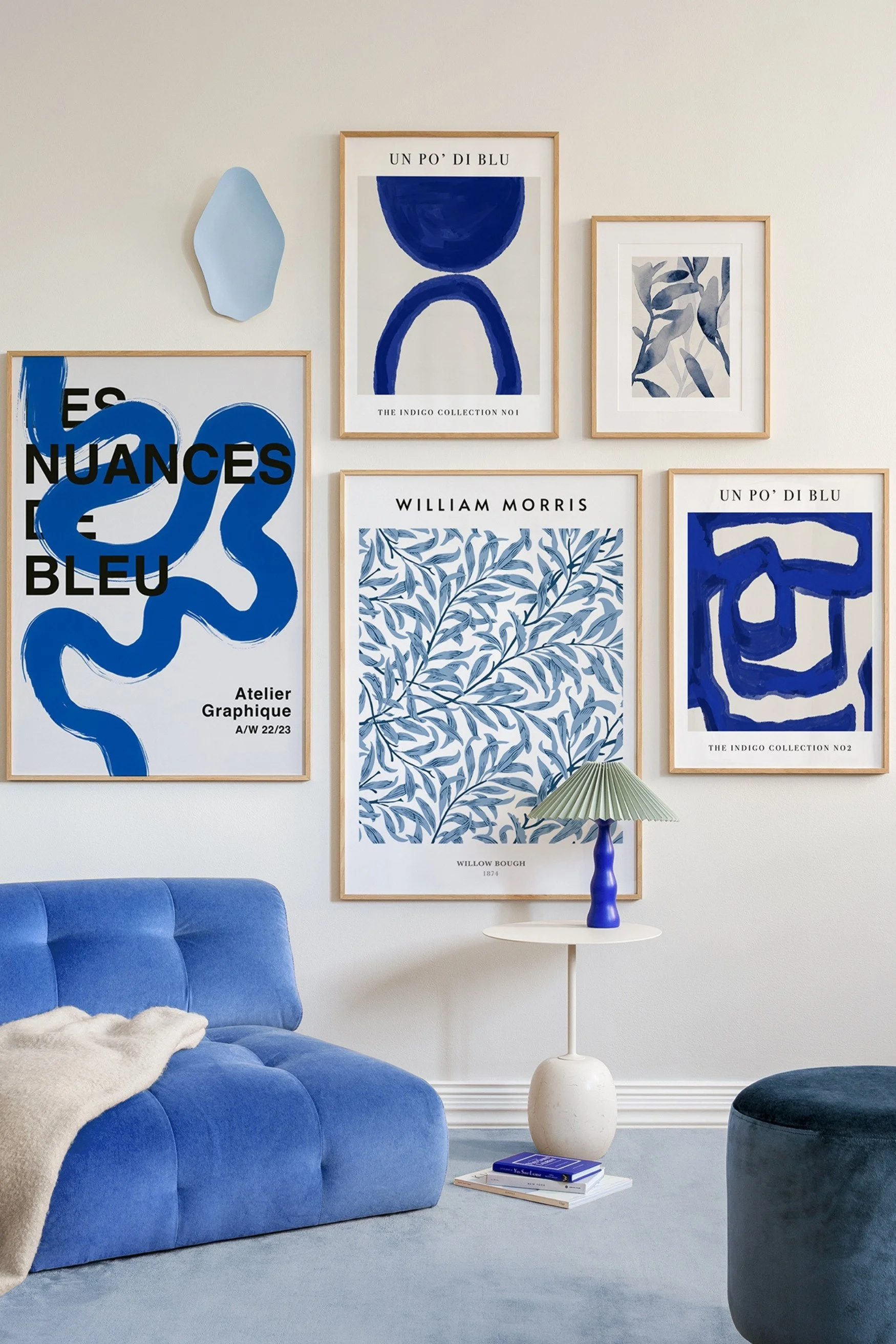 Framed prints with mainly blue artwork next to a blue chair