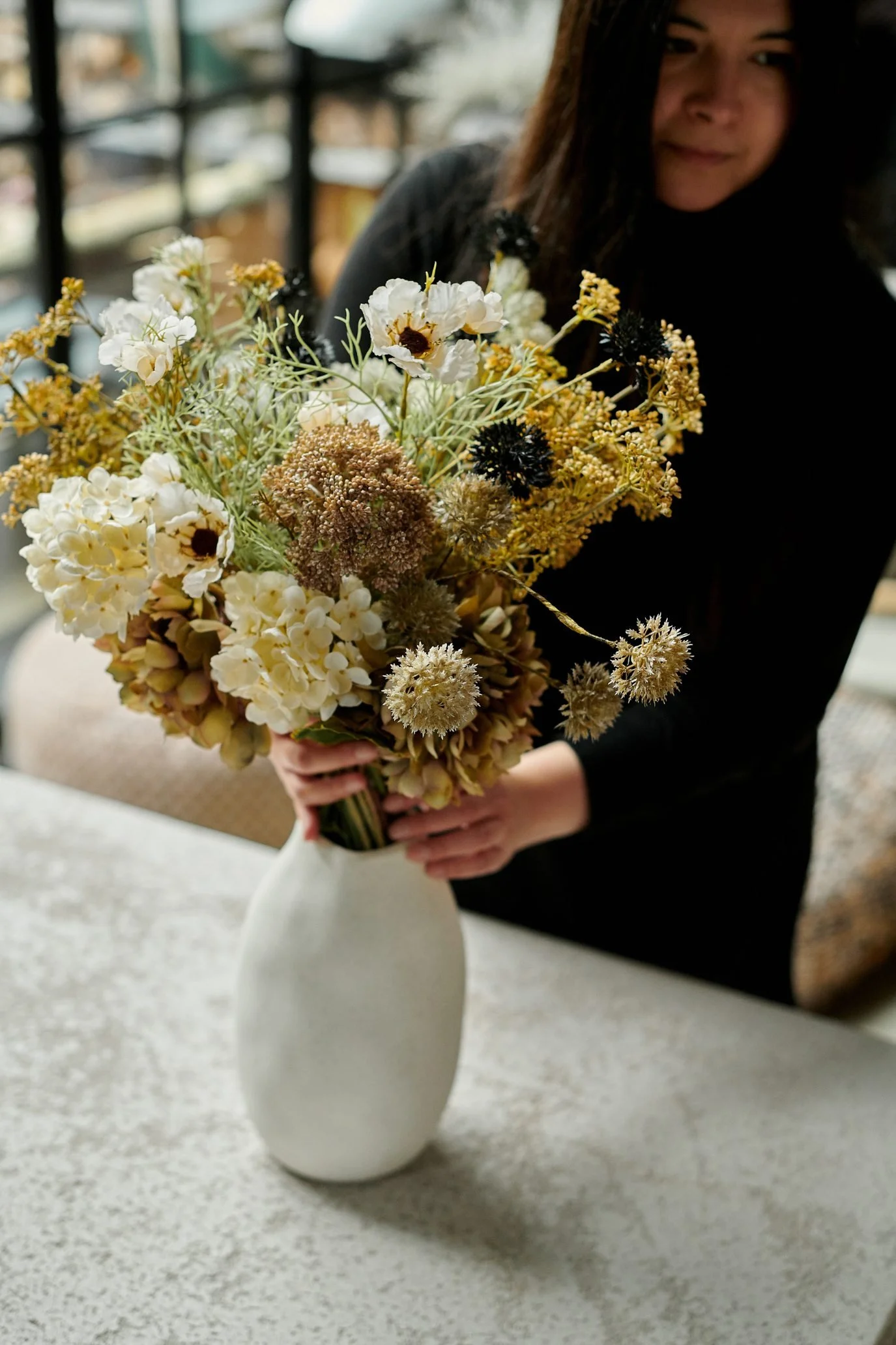 Natural-style faux flower arrangement with white blooms, hydrangeas and textured stems.
