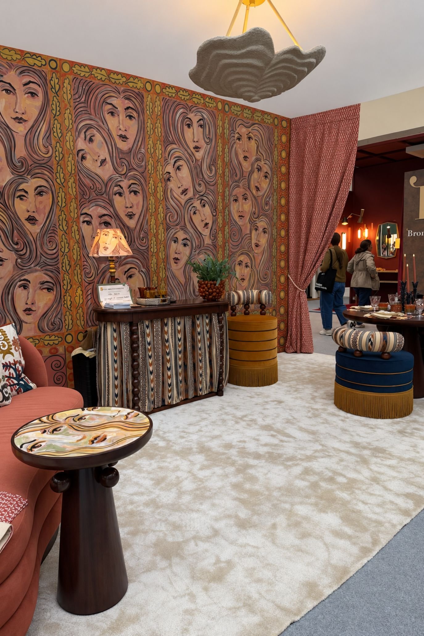 Stylised female faces repeated across wall panels and furniture on the Hyde House stand.
