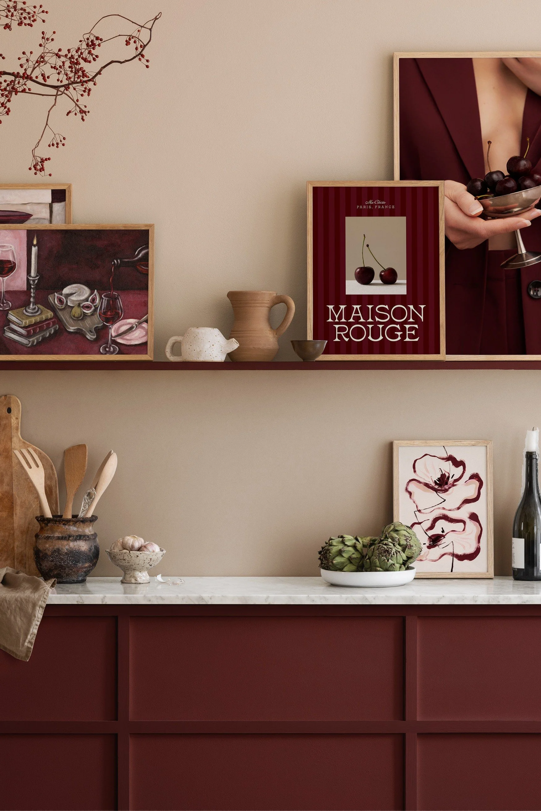 A Burgundy-toned kitchen with a shelf with frames in the same tone