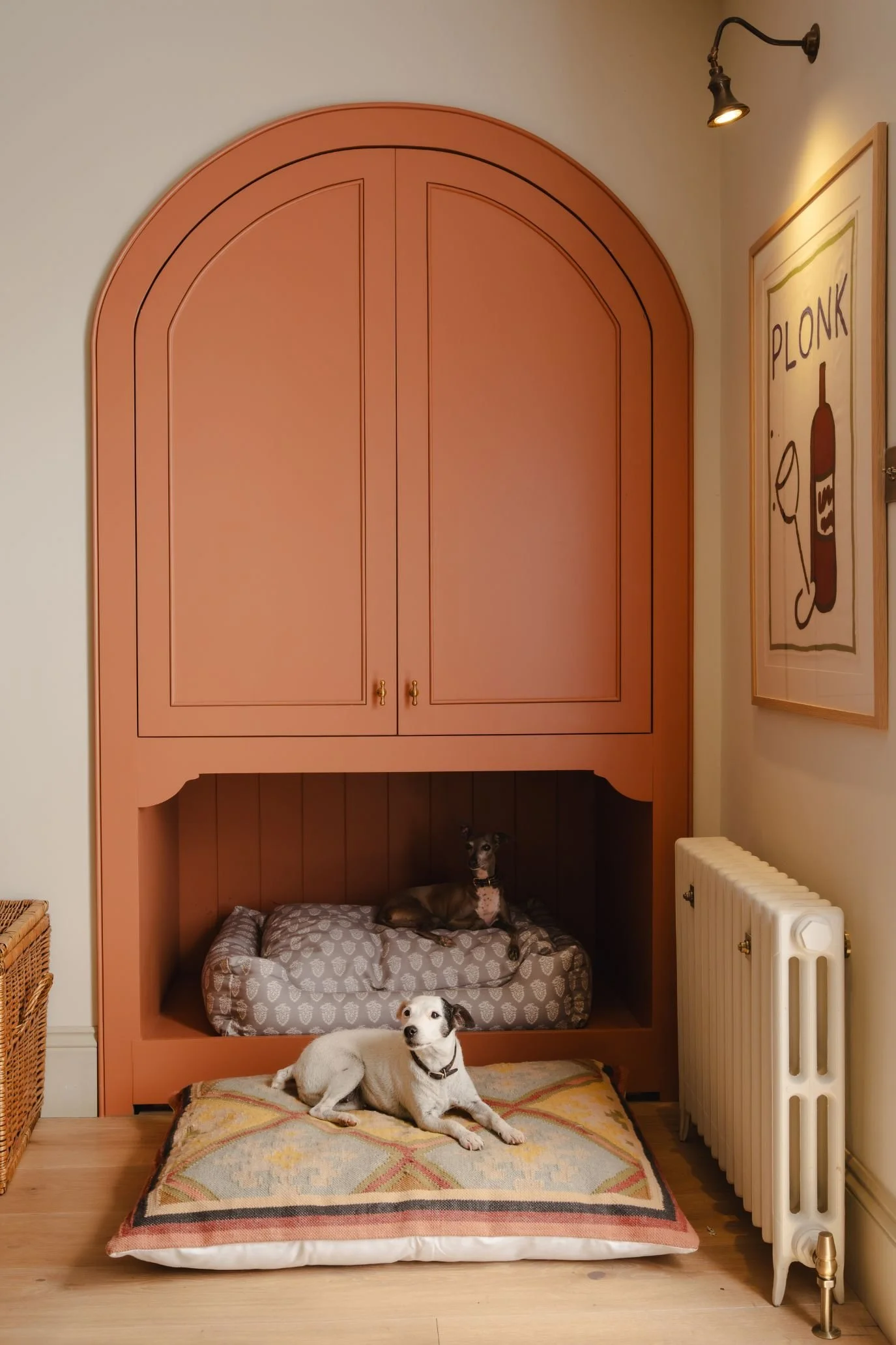 Stylish patterned dog bed beside woven planters in a contemporary interior.